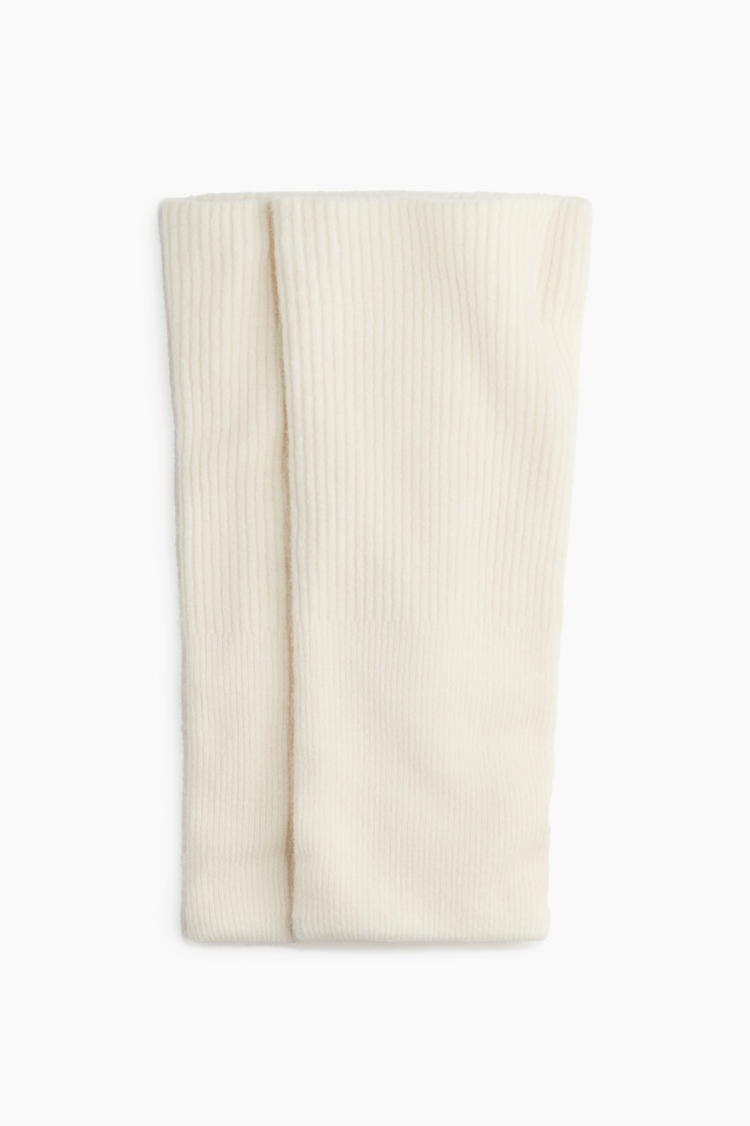 Une paire de chauffe-bras en maille cÃ´telÃ©e de couleur crÃ¨me est posÃ©e Ã  plat en vue de face, mettant en valeur une texture cÃ´telÃ©e verticale et une finition douce et duveteuse. Les deux piÃ¨ces tubulaires sont disposÃ©es cÃ´te Ã  cÃ´te, lâune chevauchant lÃ©gÃ¨rement lâautre.
