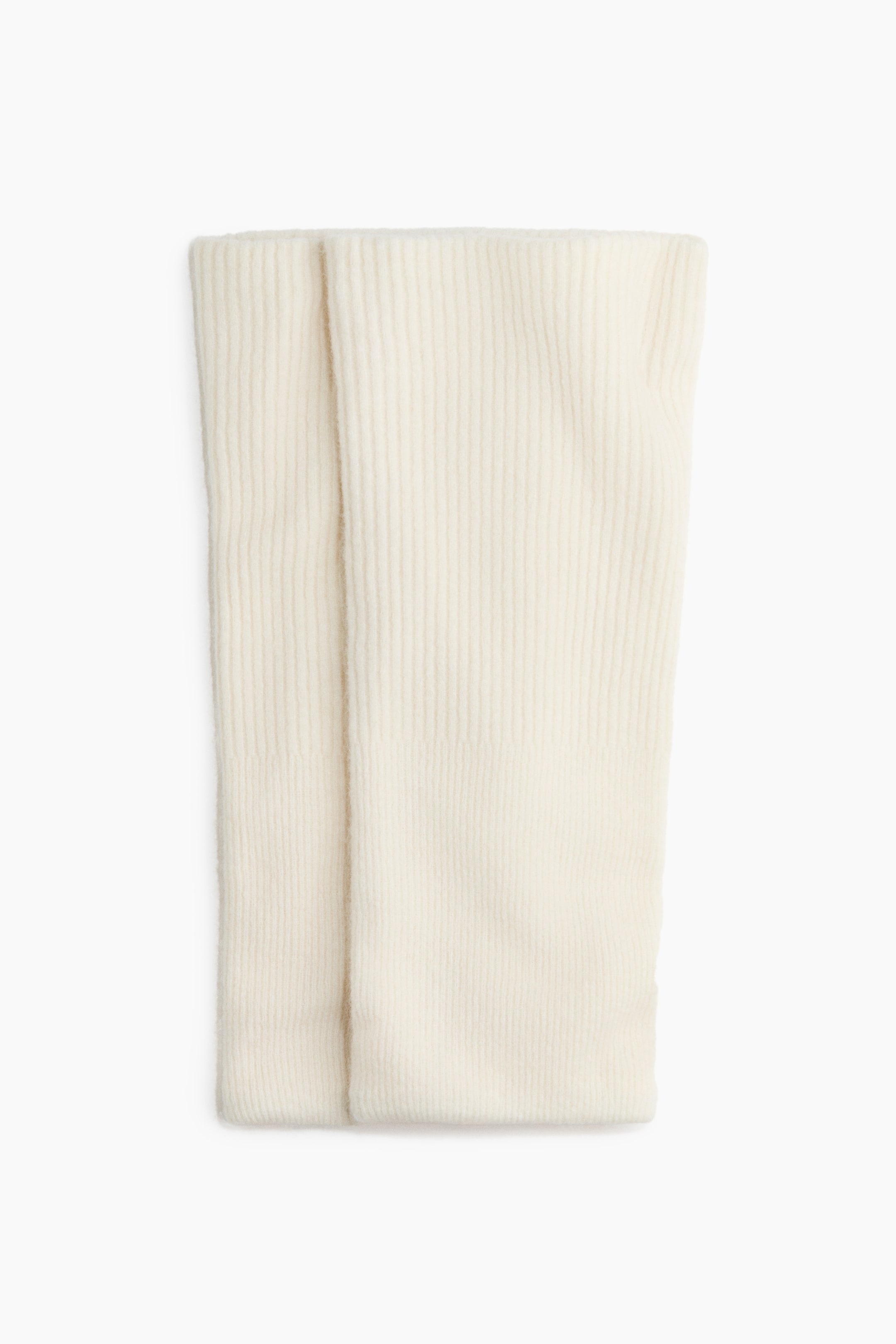 View larger image: A pair of cream-coloured ribbed knit arm warmers is laid flat in a front view, showing a vertical ribbed texture and a soft, fuzzy finish. The two tubular pieces are positioned side by side, with one slightly overlapping the other.