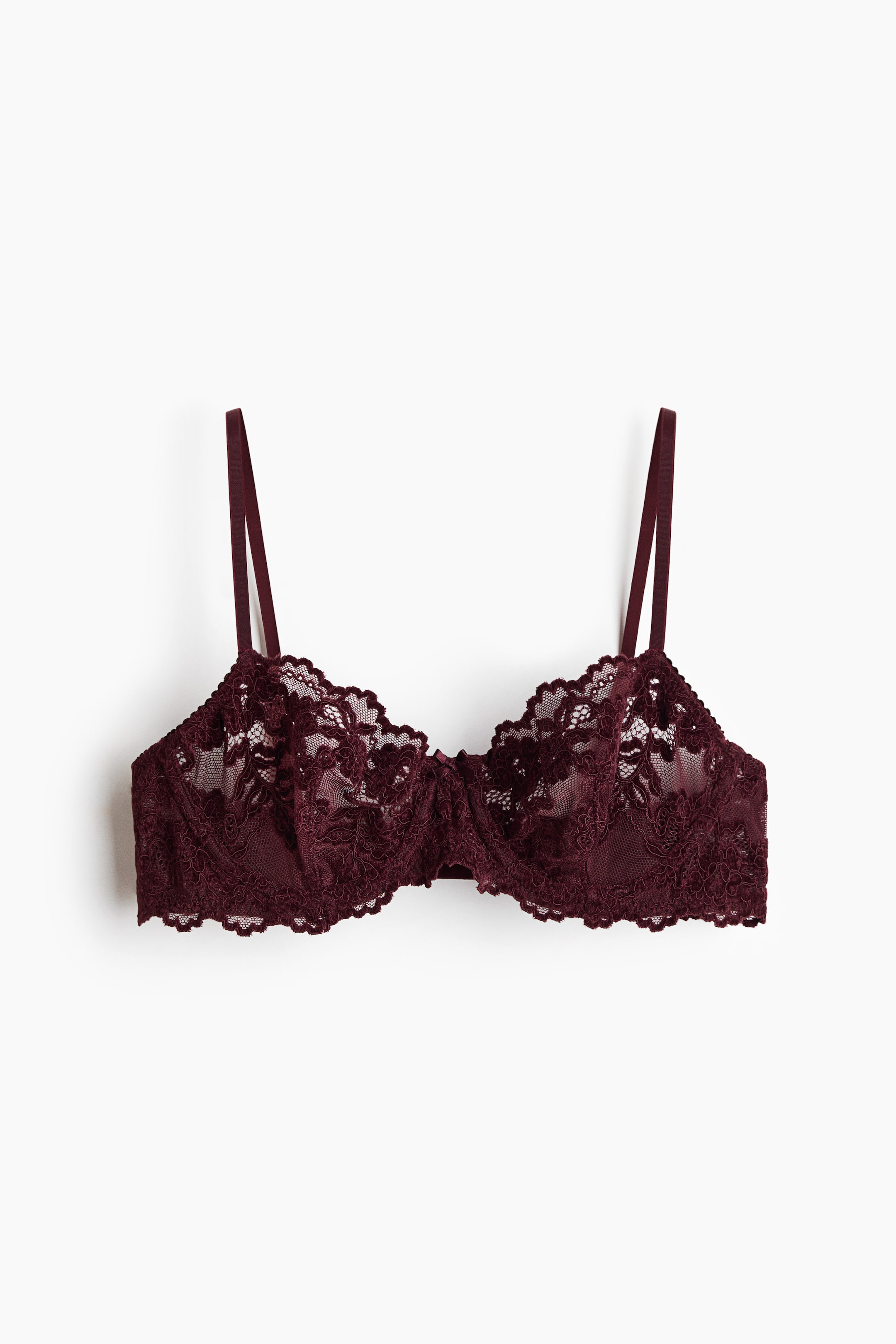Visualizza immagine più grande: Un reggiseno con ferretto color bordeaux è mostrato frontalmente, con coppe in pizzo floreale semi-trasparente con bordi smerlati e una fascia sottoseno coordinata con bordo smerlato. Il design è completato da sottili spalline regolabili e un piccolo fiocco al centro del ponte.