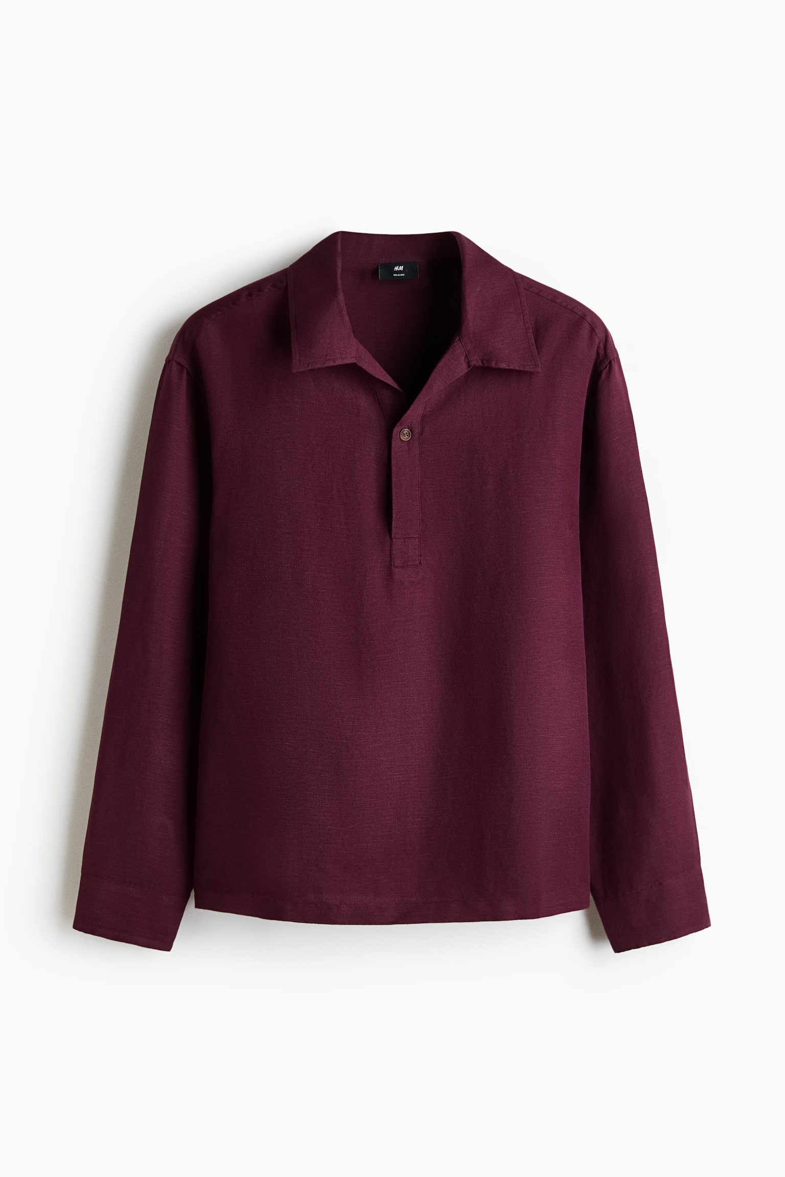 A maroon long-sleeved shirt featuring a spread collar and a partial button placket with one visible button. It boasts a textured fabric and plain long sleeves. - 1