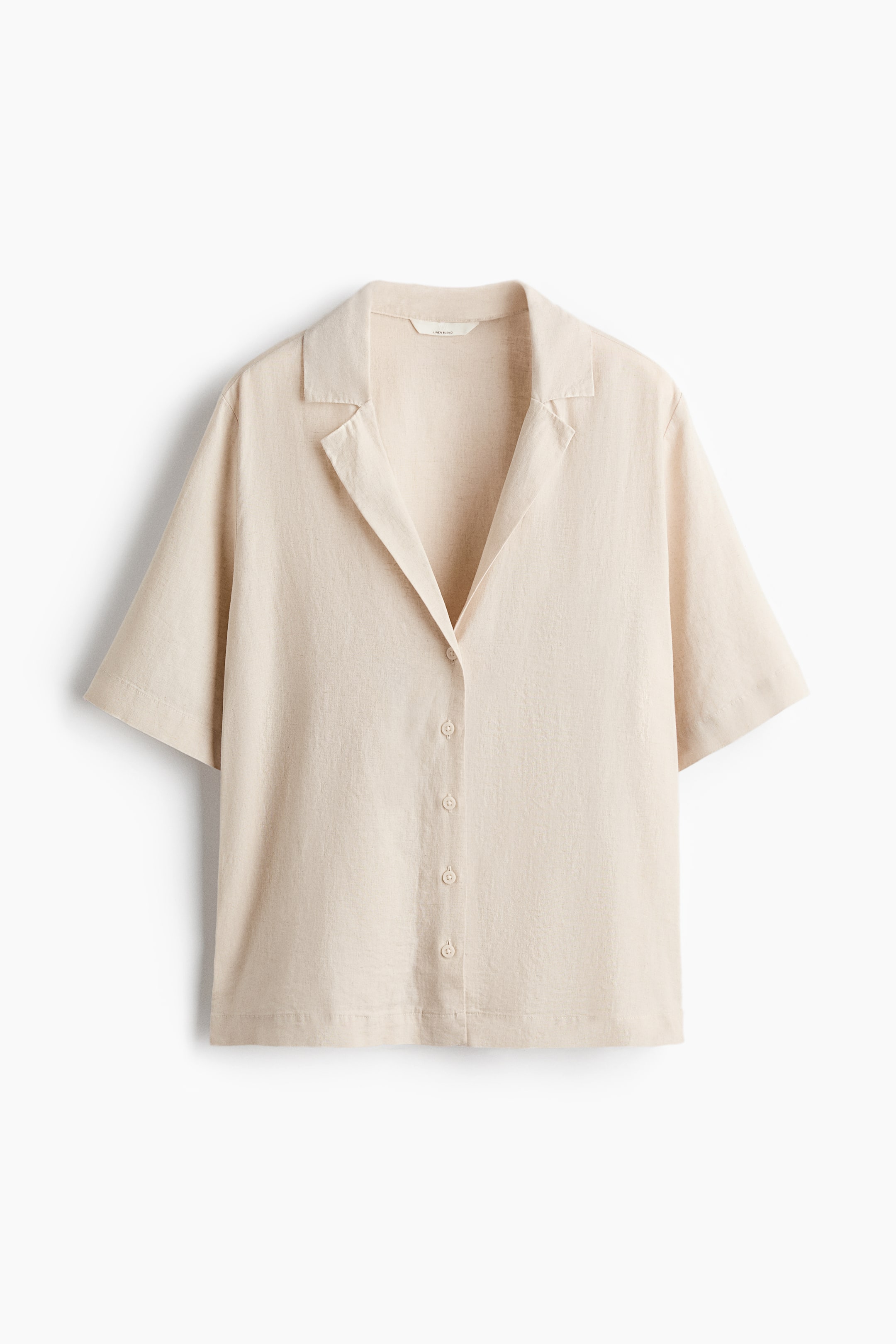 Xem ảnh lớn hơn: Áo sơ mi ngắn tay màu be nhạt được trình bày từ phía trước, nổi bật với cổ áo kiểu trại và hàng nút phía trước với các nút cùng màu sáng. Chiếc áo sơ mi này thể hiện chất liệu vải có kết cấu tinh tế.