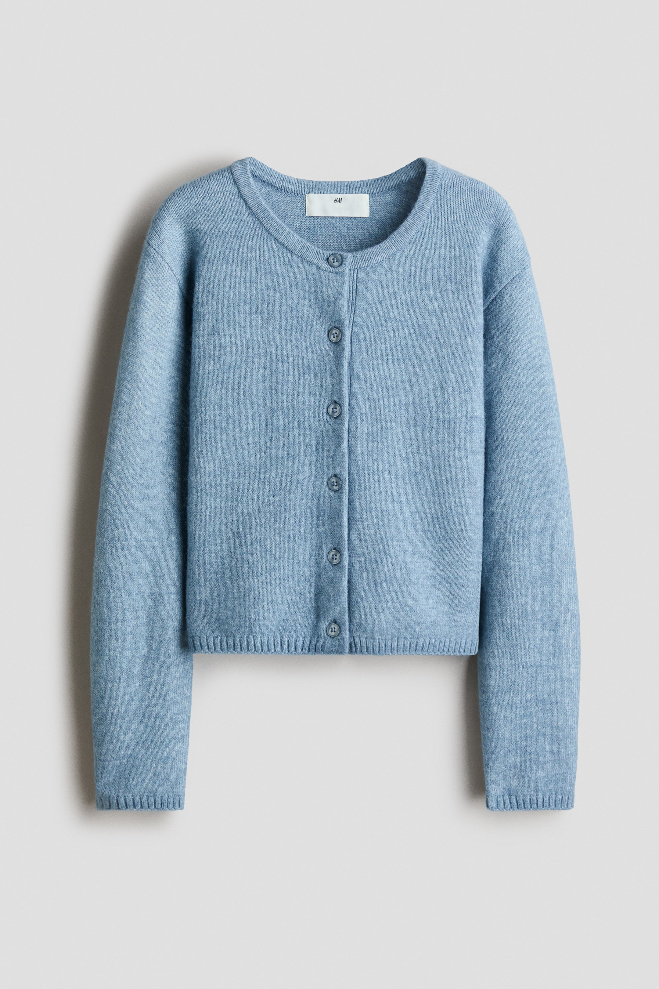 View larger image: A light blue cardigan features a round neckline and a button-front closure with six matching buttons. It also features long sleeves with ribbed cuffs and a ribbed hem.