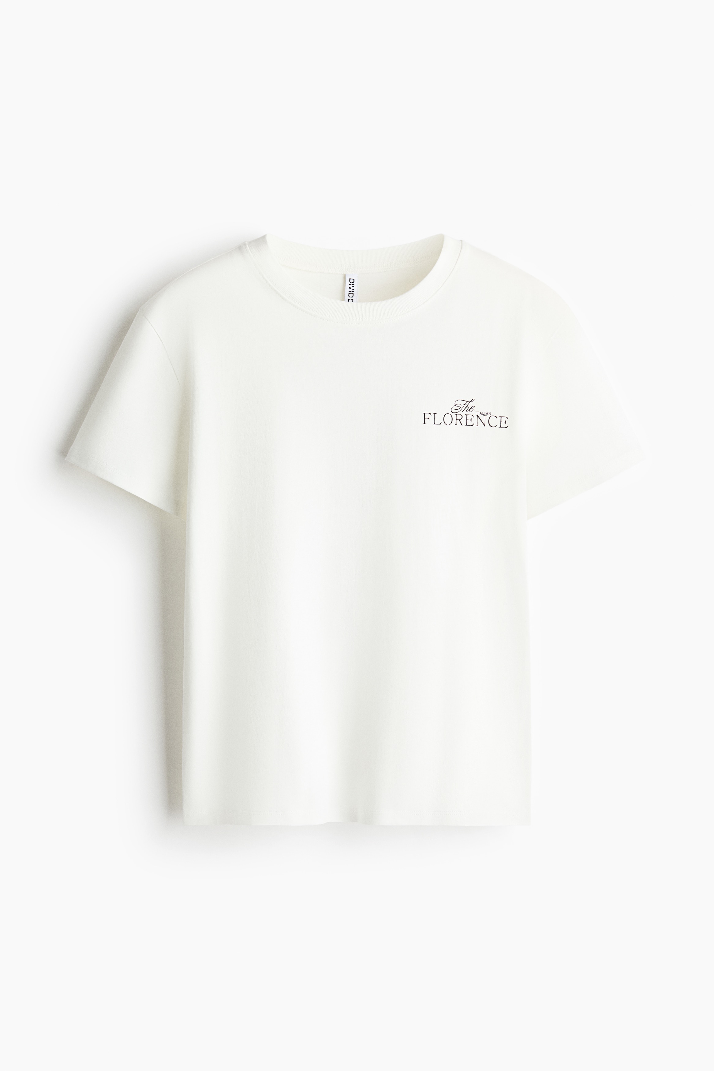 A white cotton jersey t-shirt is being worn by the model, who is turned to show the back of the garment. The back of the t-shirt features a graphic print depicting a pearl-filled dessert in a silver cup with the text "The ITALIAN FLORENCE" printed underneath.