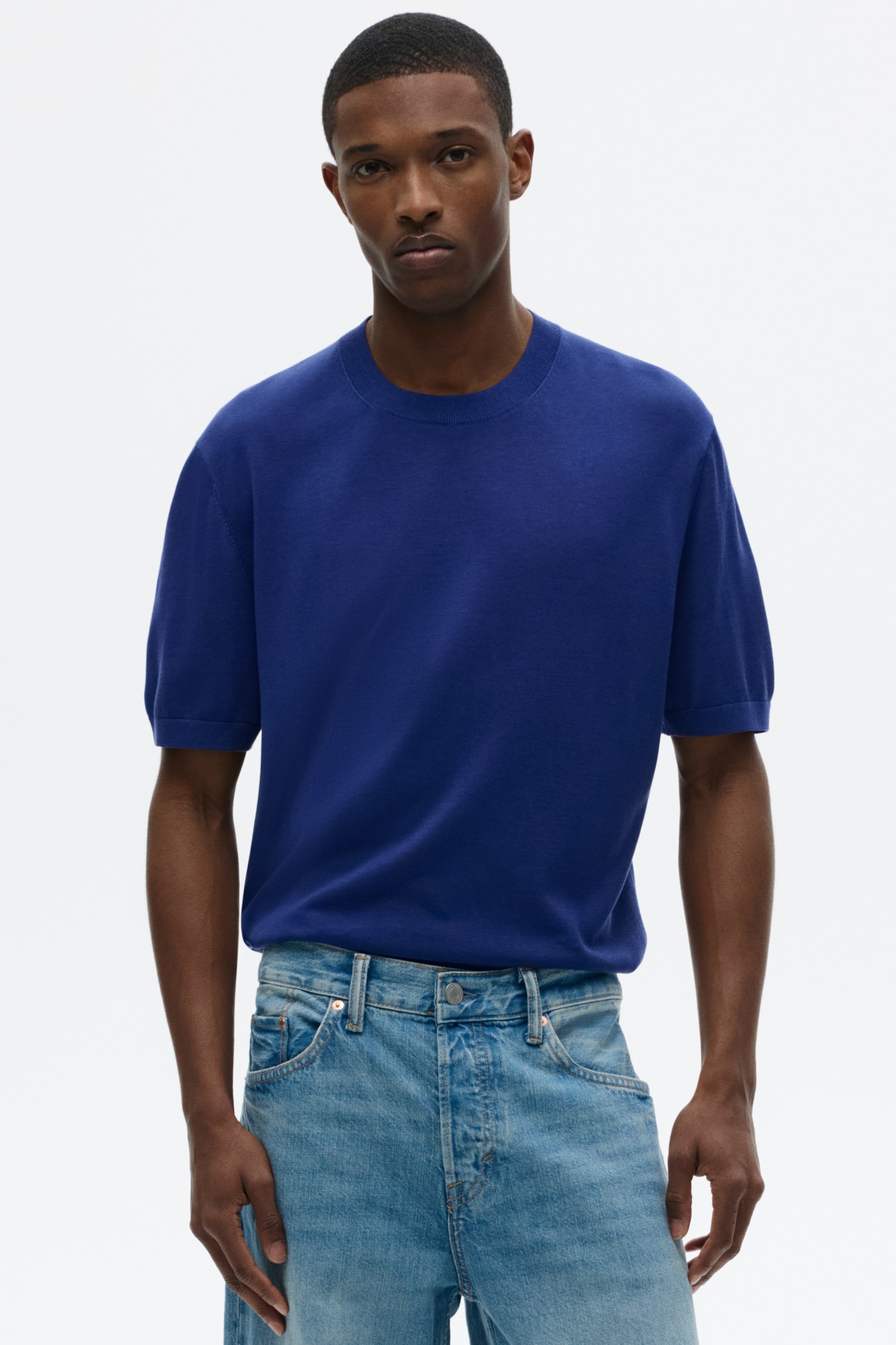 Xem ảnh lớn hơn: Chiếc áo dệt kim tay ngắn màu xanh hoàng gia có cổ tròn gân và ống tay ngắn bo gân. Bề mặt nổi bật với kết cấu dệt kim mịn, mắt dệt nhỏ.