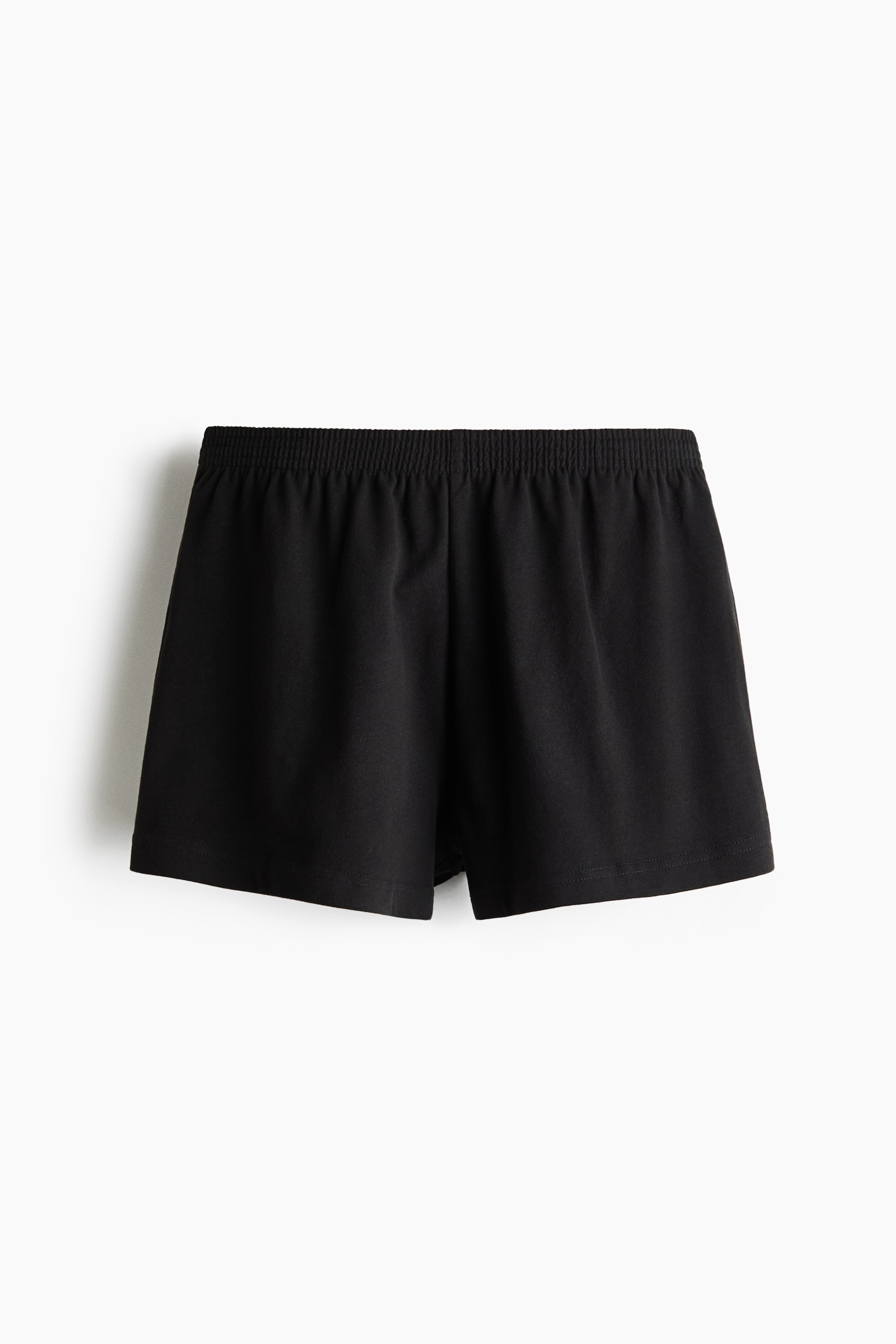View larger image: Black shorts are facing forward, featuring a shirred elastic waistband. The shorts showcase a relaxed fit and a straight hem.