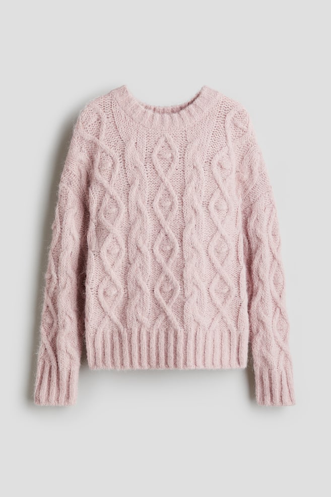 A light pink cable-knit sweater is presented, displaying its front. It is featuring a crew neck, ribbed cuffs, and a ribbed hem, with the knit patterned with intertwined cables and diamond shapes, and appearing slightly fuzzy. - 1