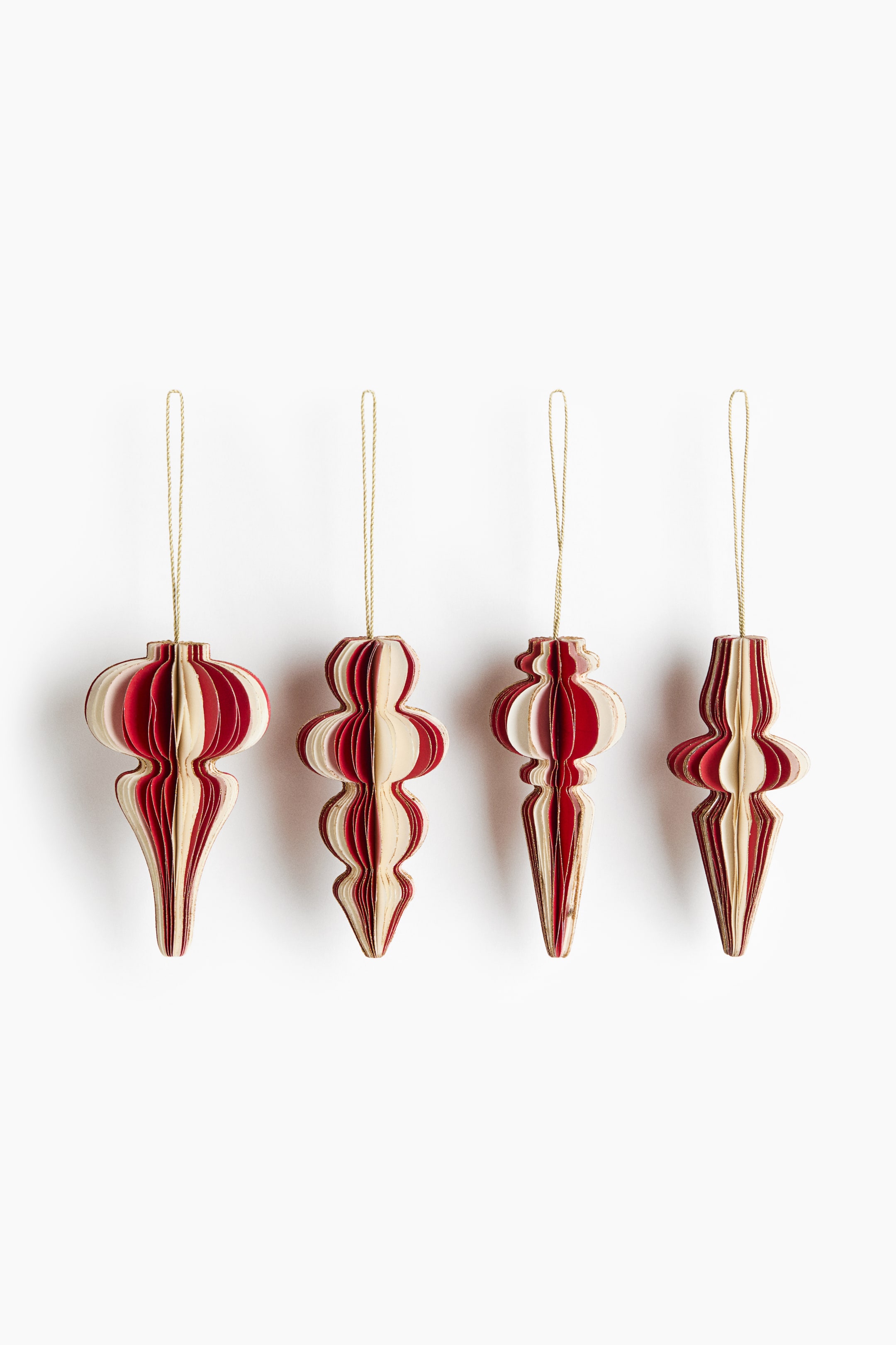 Visa större bild: Ett set med fyra juldekorationer hänger i tunna guldfärgade snören, där varje ornament visar en unik 3D-krönform tillverkad av lager av röd och krämfärgad kartong. Ornamenten uppvisar en strukturerad, dragspelsliknande design med fint glitterbesprutade kanter.