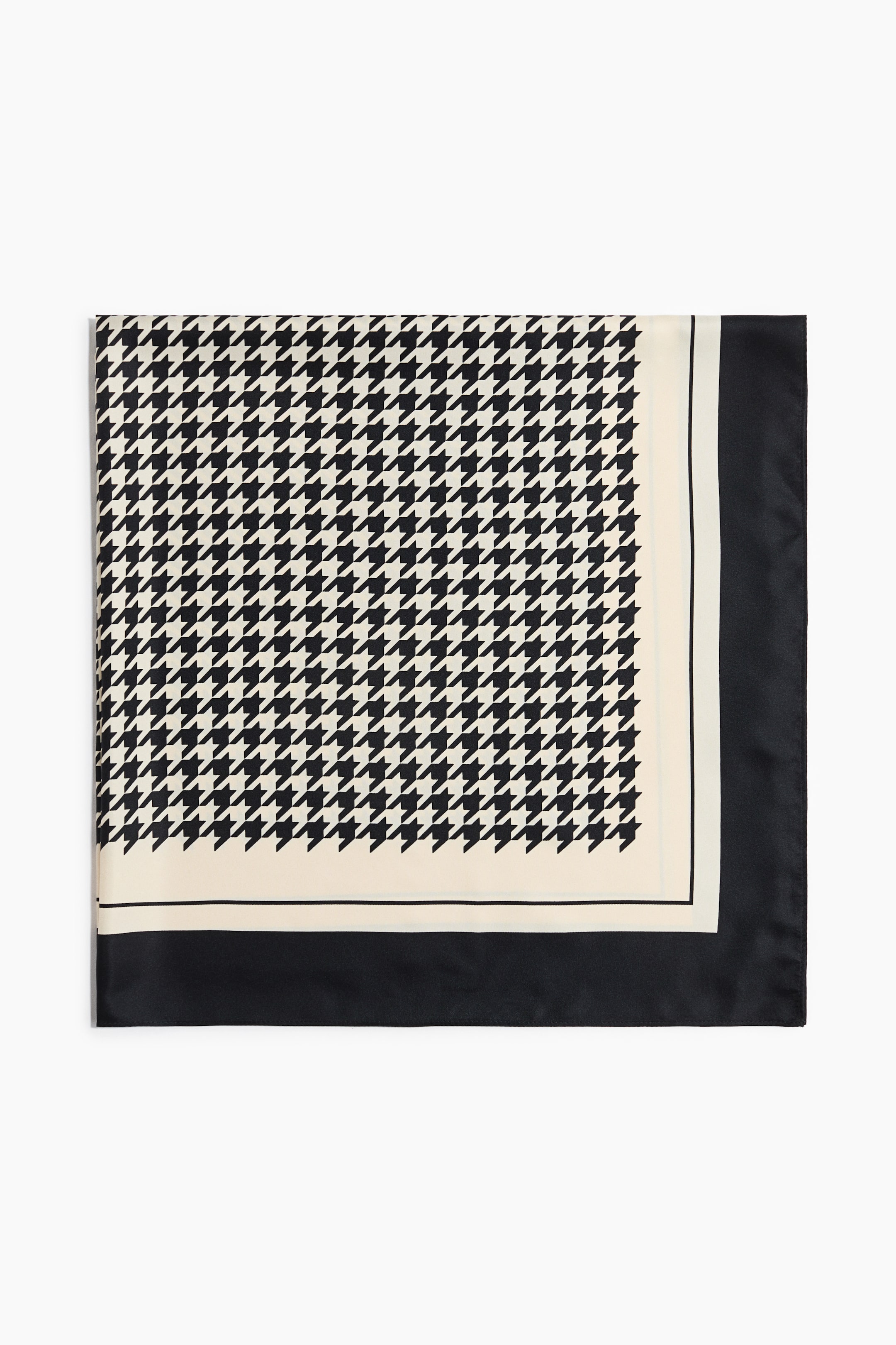 View larger image: A square scarf in a soft weave is lying flat in a front view, showcasing a printed black and cream houndstooth pattern in the centre. The design is framed by a cream-coloured border with a thin black stripe and a wide solid black outer edge.