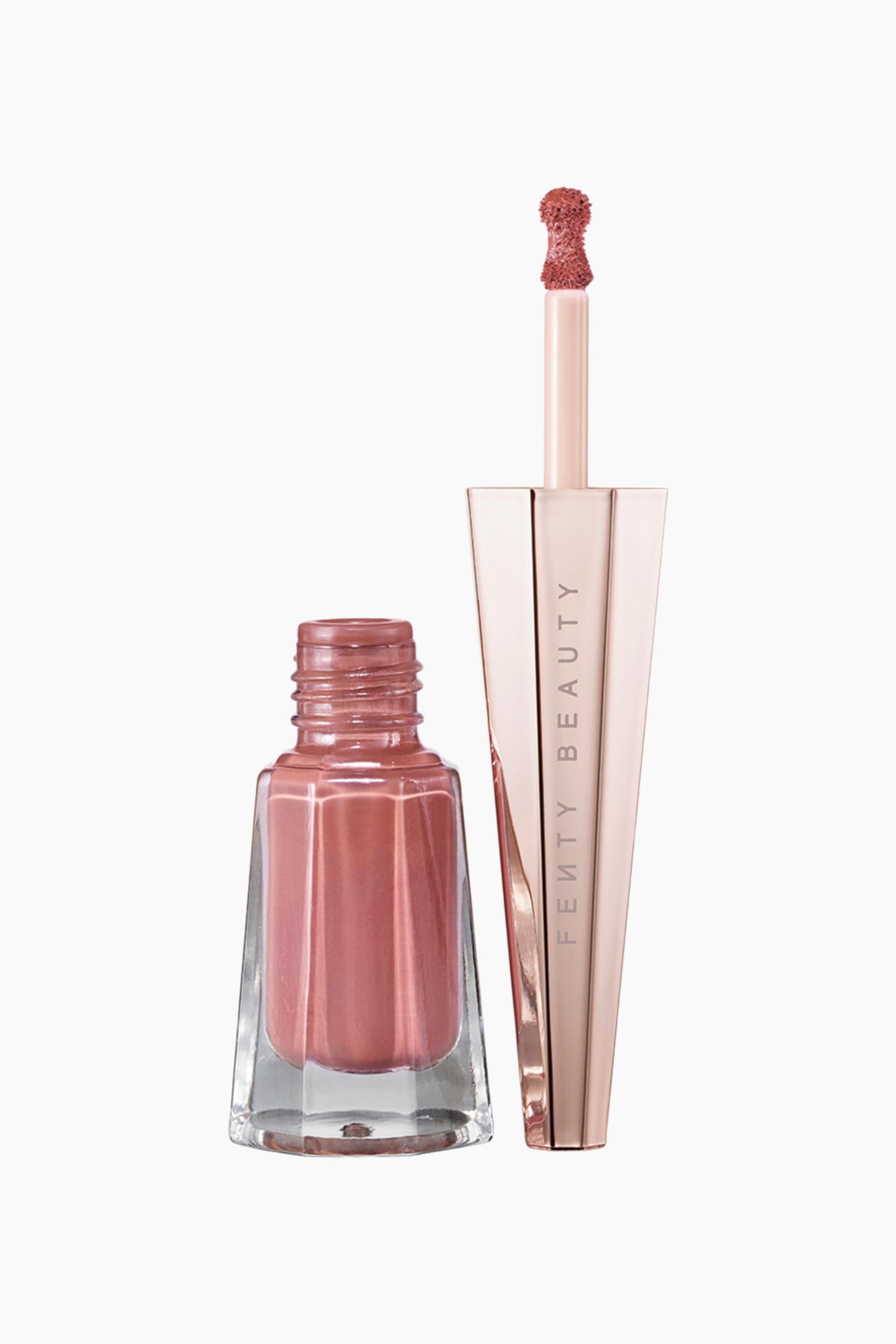 Visa större bild: Stunna Lip Paint Longwear Fluid Lip Color står upprätt och visar en öppen, facetterad glasflaska fylld med ett dammigt rosatonat flytande läppstift, bredvid dess avtagna geometriska kork i roséguld. Den höga, kantiga korken visar varumärkesnamnet vertikalt, medan applikatorn pekar uppåt för att framhäva den matchande nyansen på dess precisionssvampudd.
