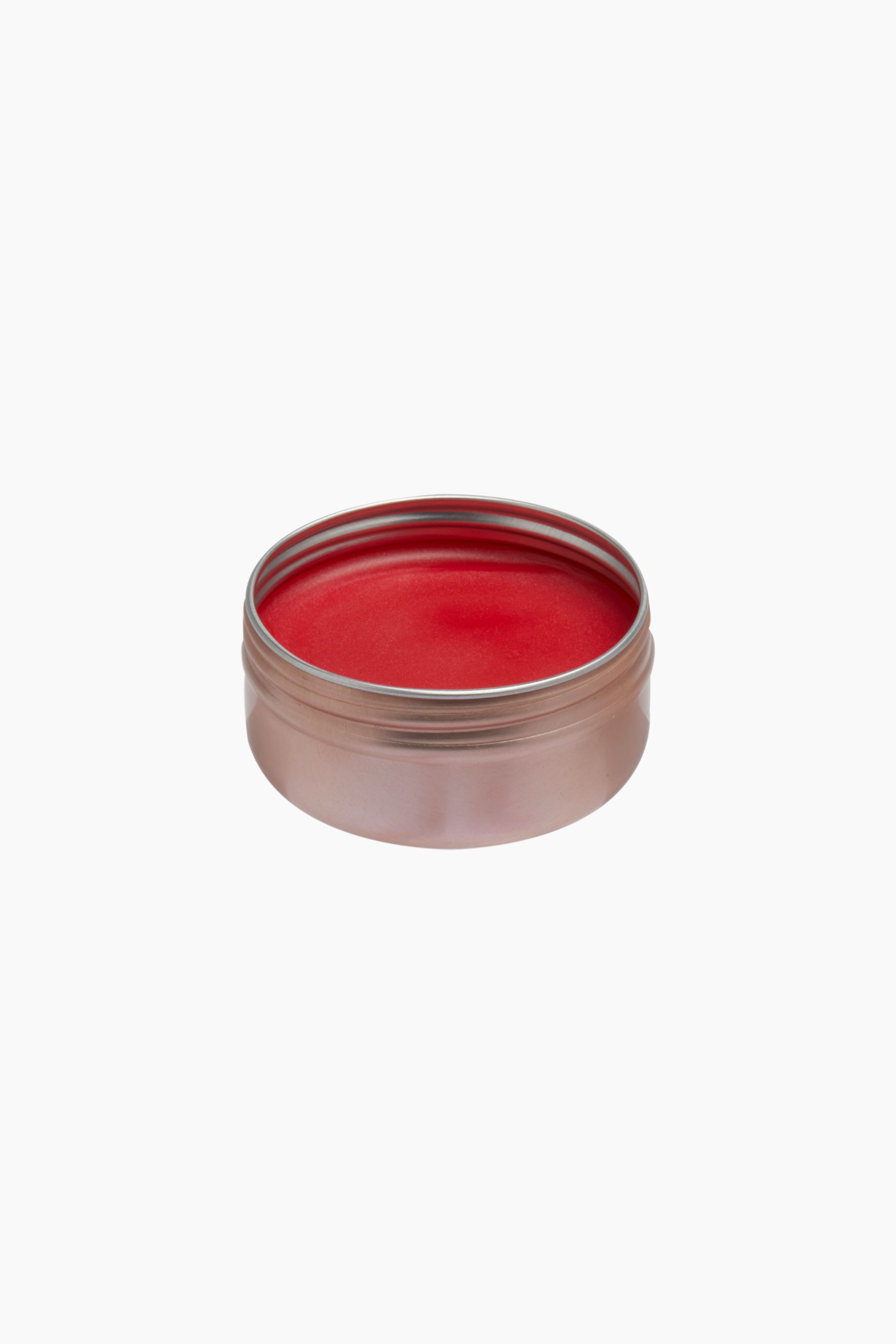 Größeres Bild ansehen: Eine runde, metallische roségoldene Dose liegt in einem Dreiviertelwinkel und zeigt im Inneren einen leuchtend roten Creme-Balm mit einer glatten, glänzenden Textur.