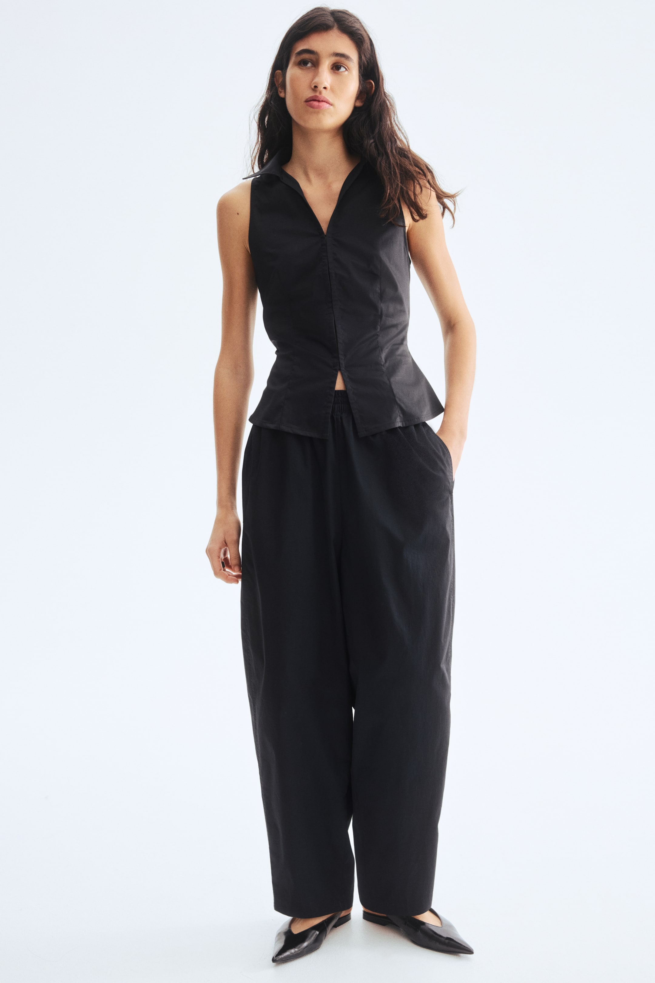 View larger image: The top is featuring a pointed collar, a V-neckline, and a fitted bodice that is gently flaring at the hem, while the pants are showcasing a relaxed fit with an elasticated waist and side pockets.