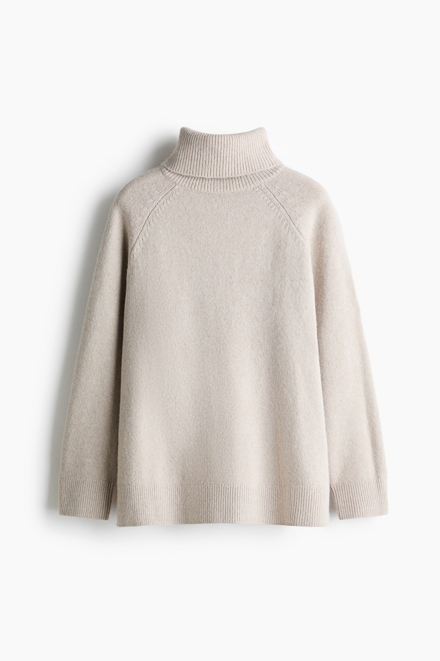 A light beige knitted jumper is shown from the front in a relaxed fit, featuring a high ribbed roll neck, raglan sleeves, ribbed cuffs, and a ribbed hem.