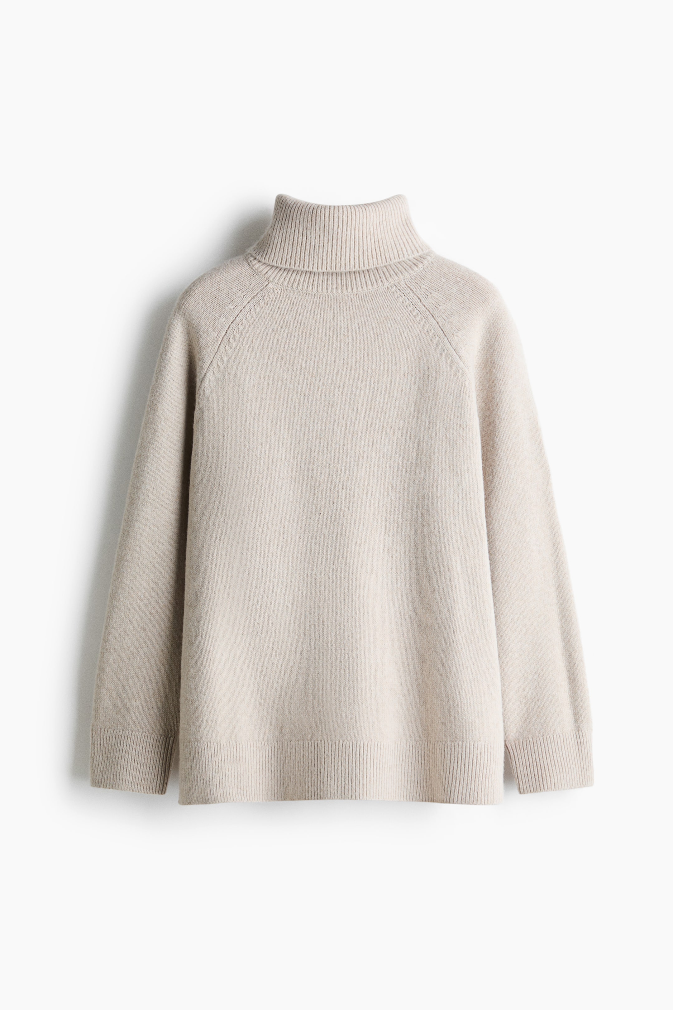 View larger image: A light beige knit sweater is shown in a relaxed fit from the front, featuring a high ribbed turtleneck, raglan sleeves, ribbed cuffs, and a ribbed hem.