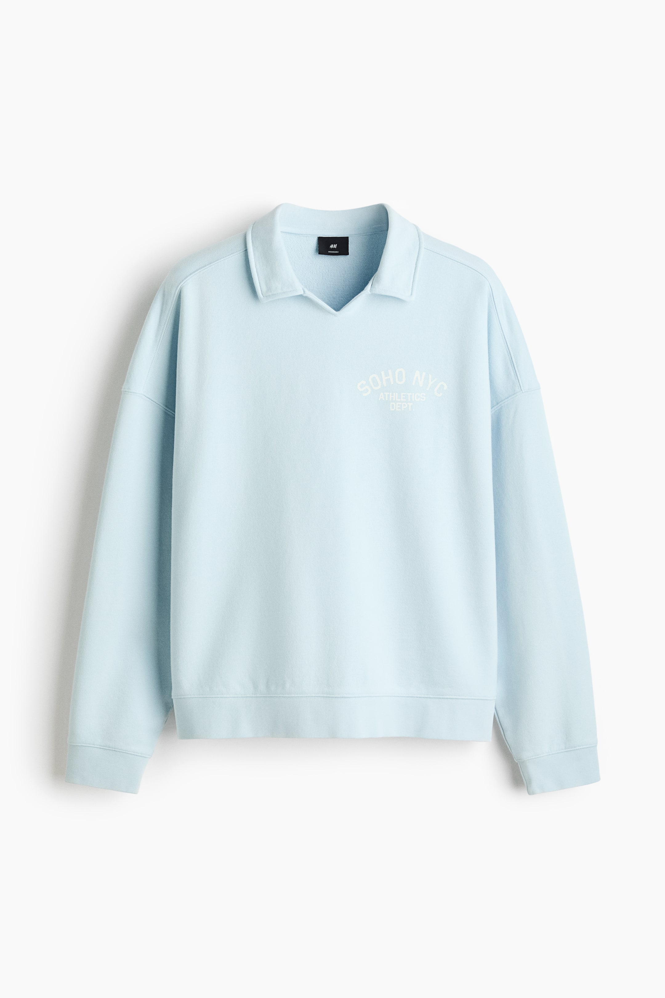 Vezi imaginea mai mare: Un hanorac albastru deschis este prezentat din față, având un guler polo cu o deschidere în formă de V. Pe piept este afișat textul "SOHO NYC ATHLETICS DEPT." imprimat în alb, și este proiectat cu umeri căzuți, manșete și tiv ribat.