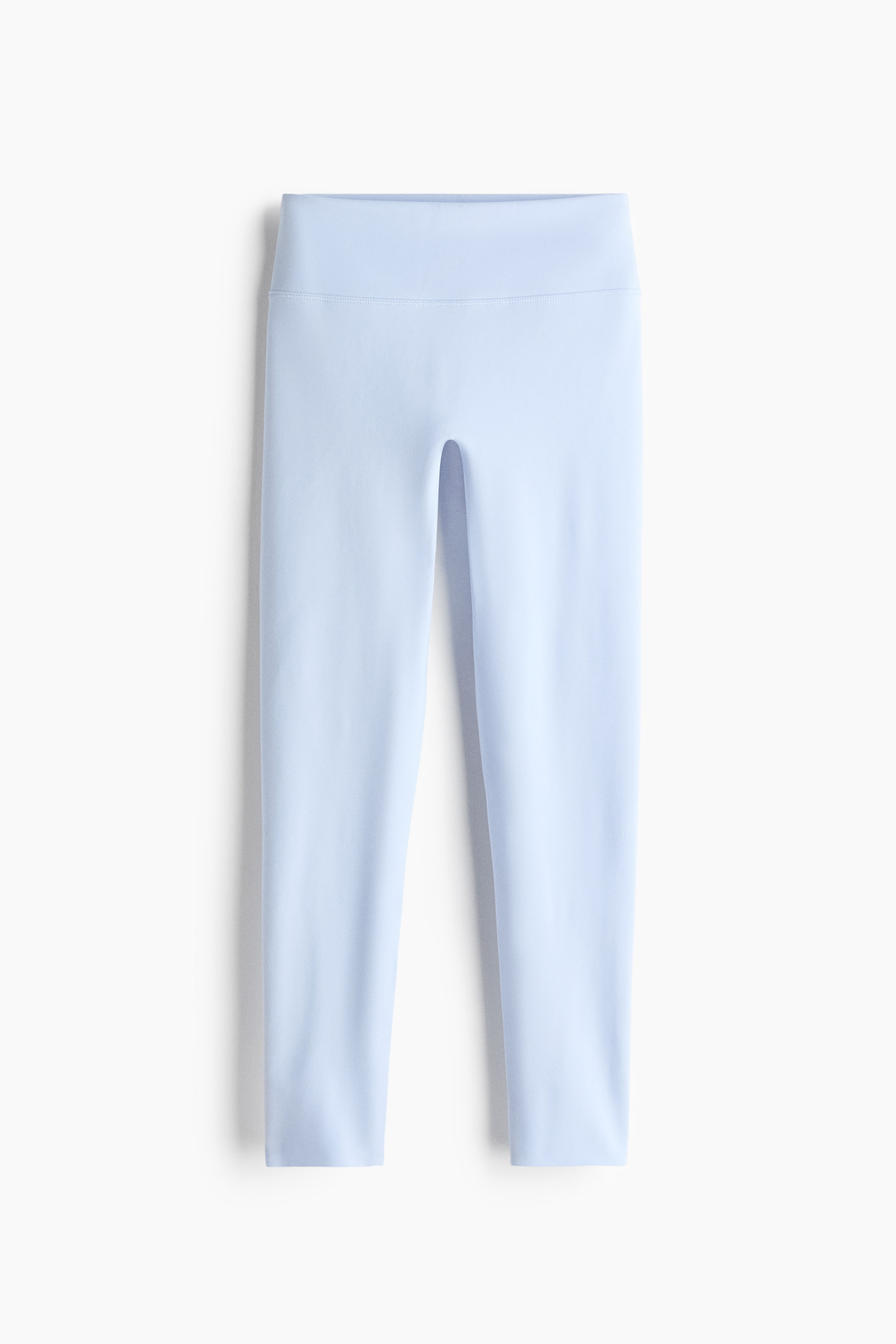 Grotere afbeelding bekijken: Lichtblauwe leggings liggen plat van voren, met een brede, hoge tailleband en een glad, naadloos ontwerp van de pijpen.