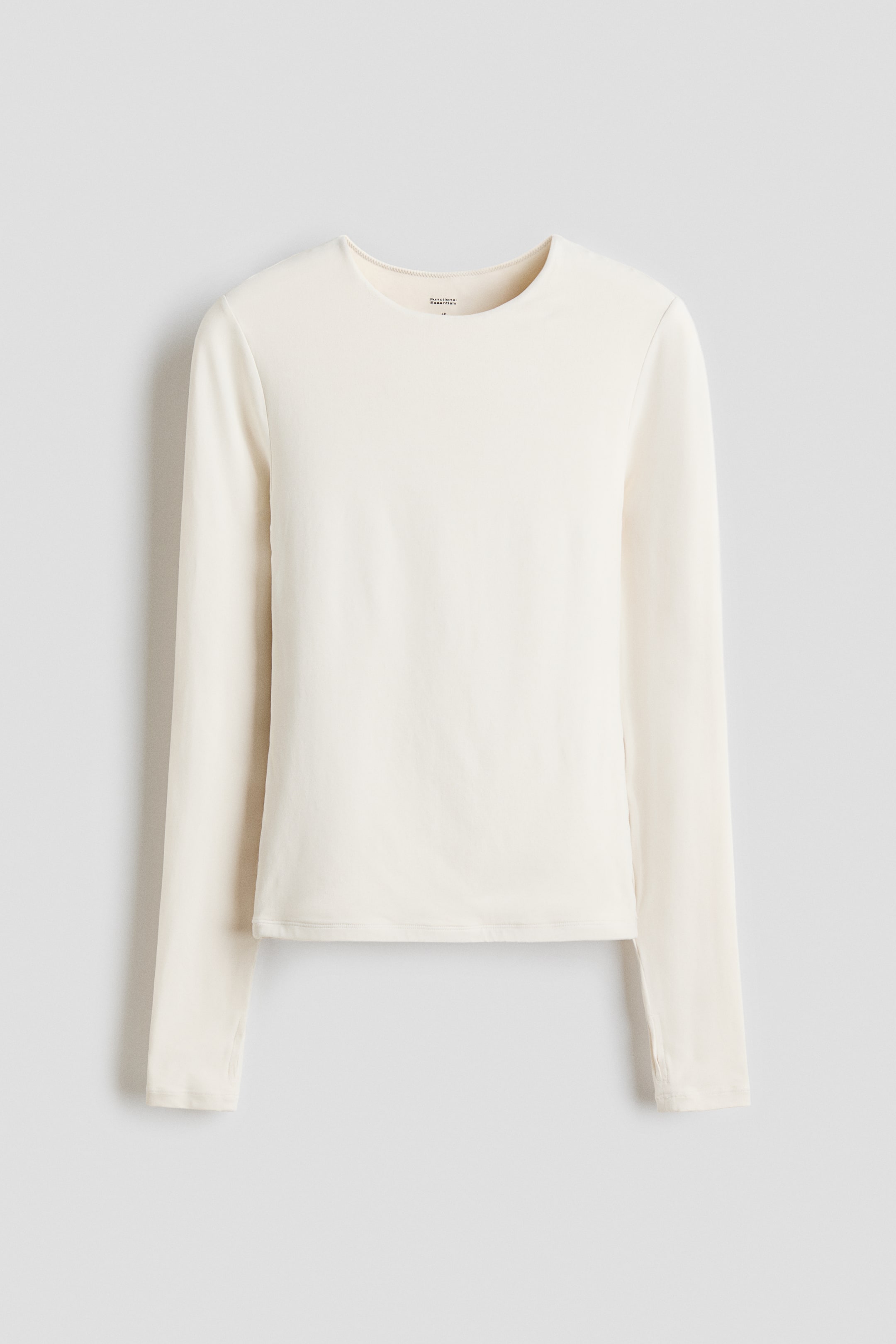 Büyük resmi görüntüle: Krem uzun kollu üst, bisiklet yaka ve uzun kollarla ÖN olarak sunulmaktadır. Pürüzsüz kumaş, alt kısmında düz bir etek ucu ile tamamlanmaktadır.