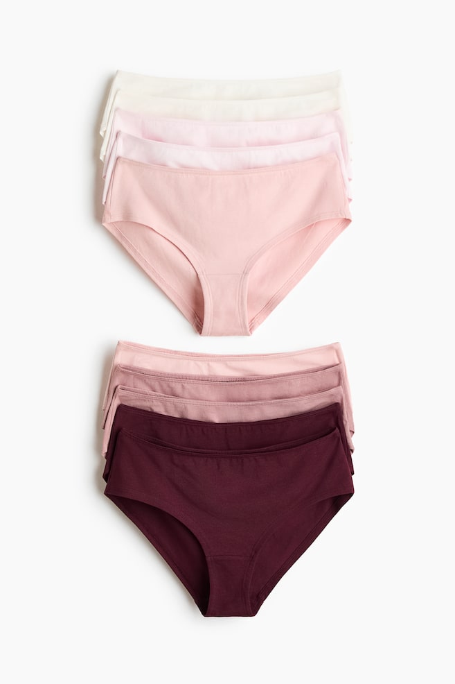 Two stacks of cotton jersey briefs are shown facing front, displaying a gradient of colours from white and light pink in the top stack to dusty rose and deep burgundy in the bottom stack. Each pair features a mid-rise waist and elasticised trim along the waist and leg openings. - 1