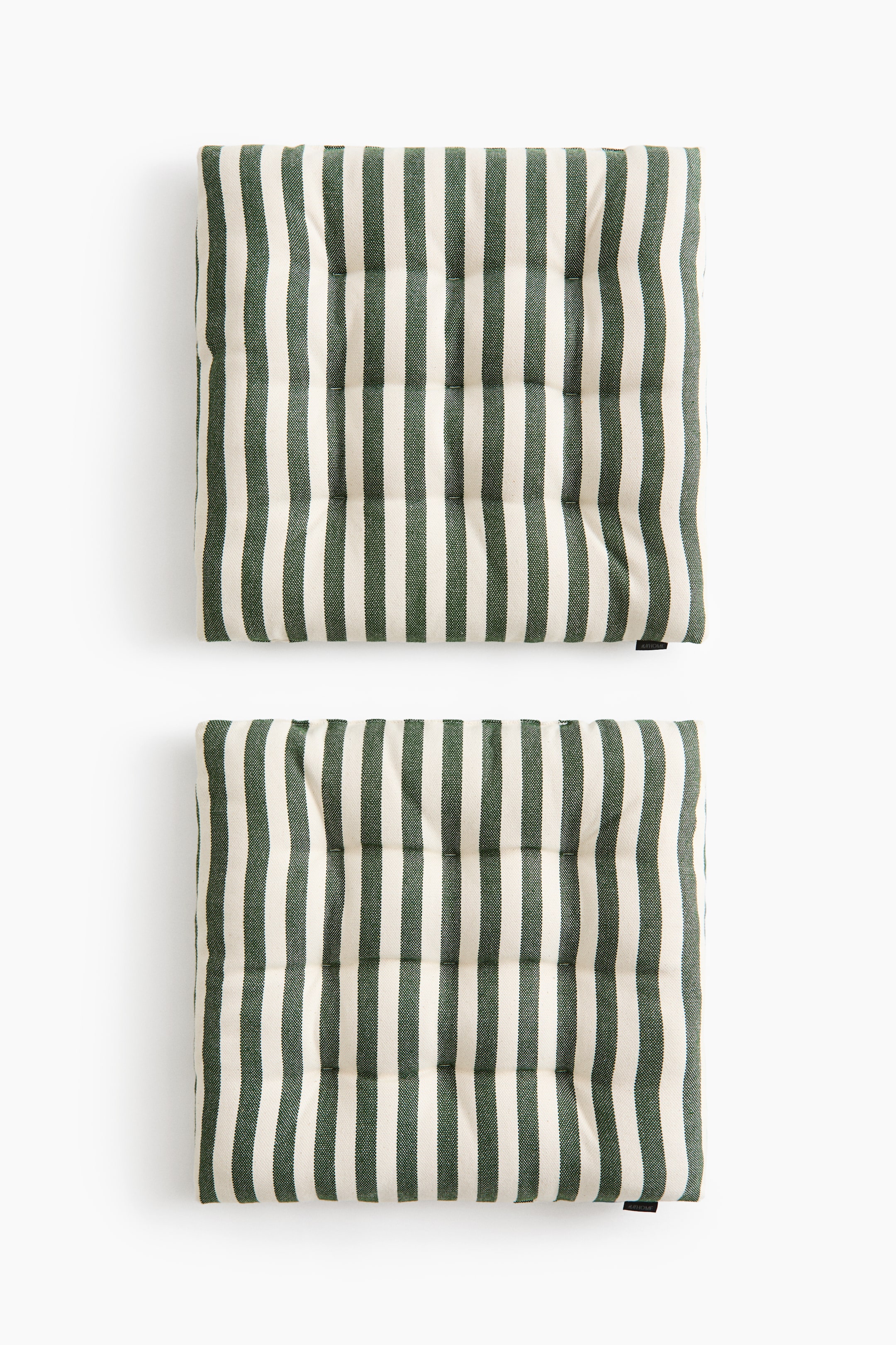 View larger image: Two square padded seat cushions are shown from a top-down perspective, featuring a vertical dark green and off-white striped pattern. Both cushions display a quilted design with tufted quilted knots arranged in a grid across the surface.