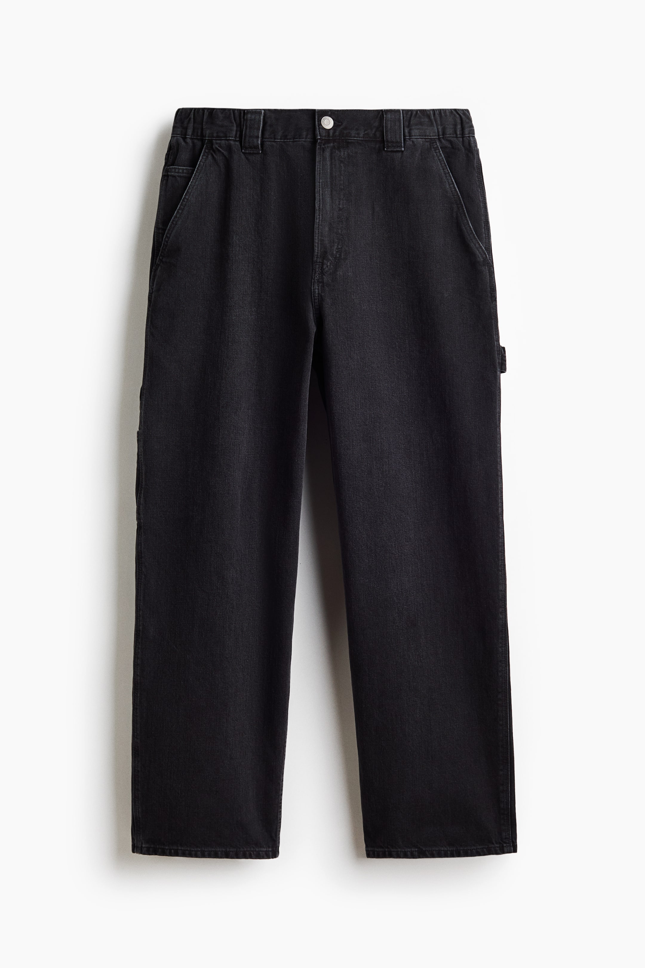 View larger image: Black carpenter trousers are shown from the front, featuring a straight-leg cut and a washed black denim texture. They display a button fastening, belt loops, and front slash pockets, along with a hammer loop and a tool pocket on the right leg.