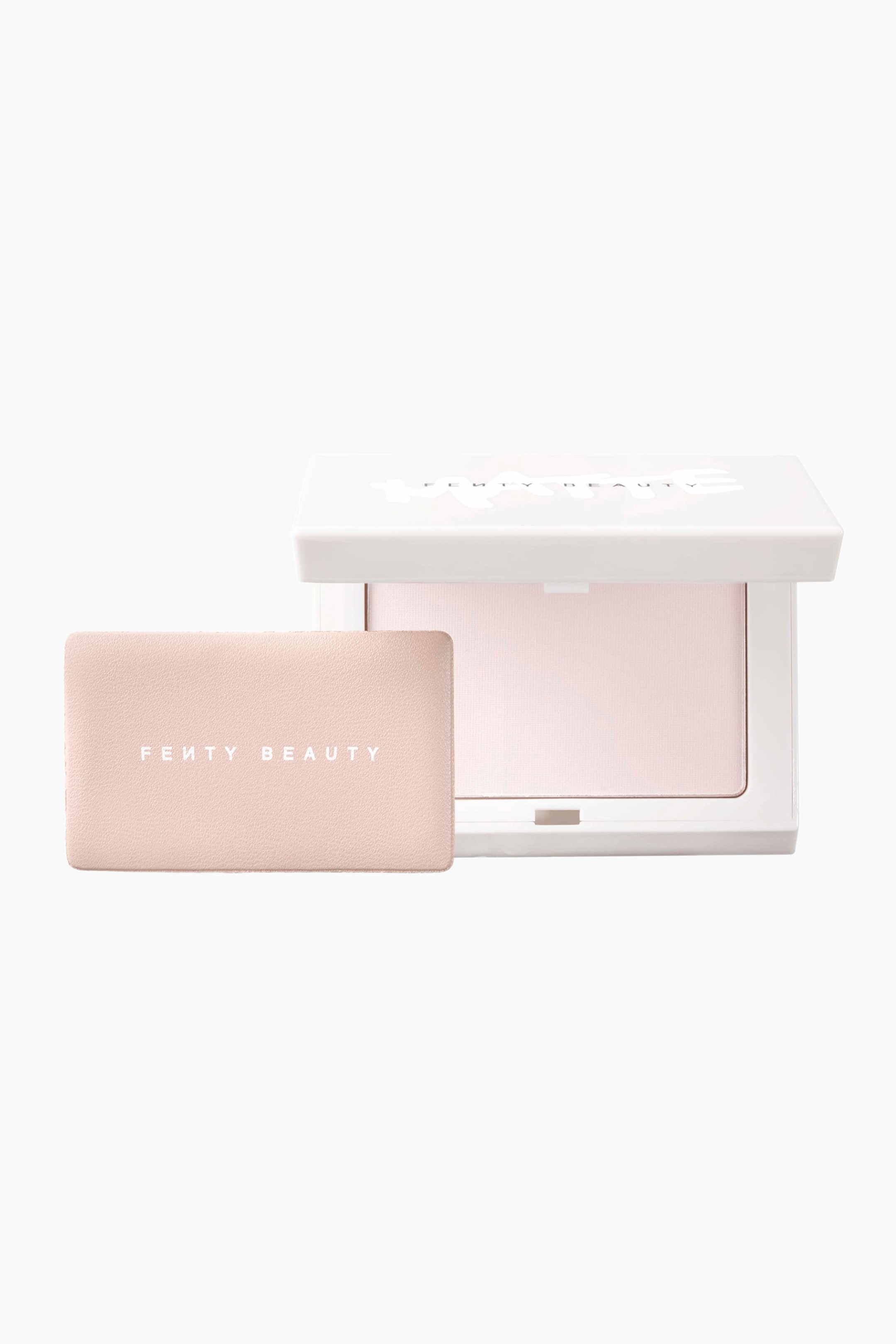 Visa större bild: Invisimatte Instant Setting + Blotting Powder presenteras i ett öppet, vitt rektangulärt etui som vetter framåt och visar en ljusrosa pressad puderplatta. En rektangulär appliceringssvamp i nude-rosa med ”FENTY BEAUTY”-logotypen i vitt ligger till vänster om etuiet.