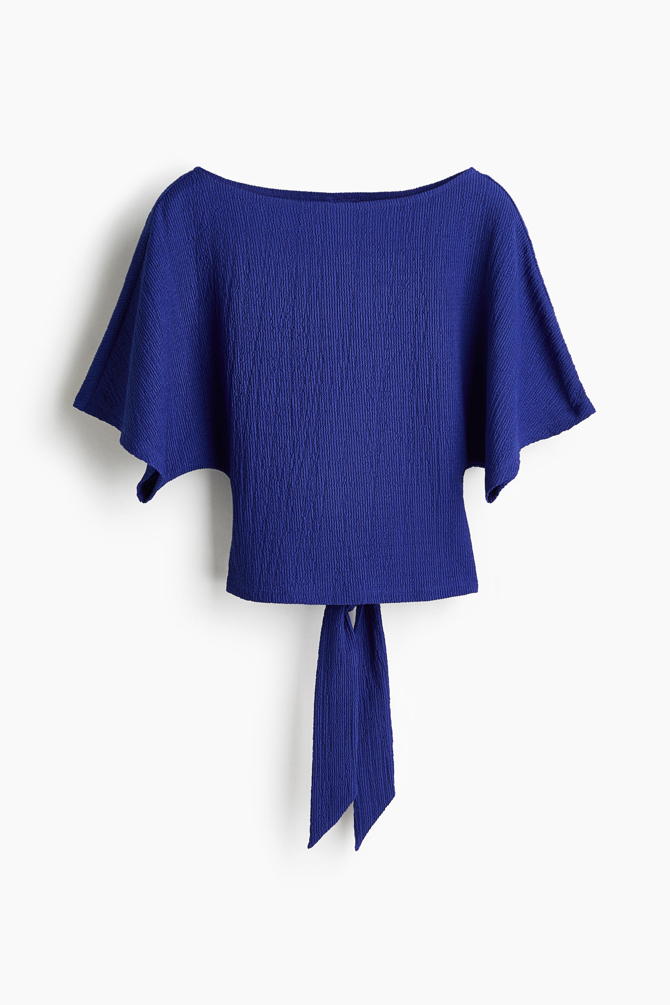 View larger image: The product is a royal blue textured top, showcasing a wide boat neckline and short, flowing kimono sleeves. Two long fabric ties extend from the straight back hem.