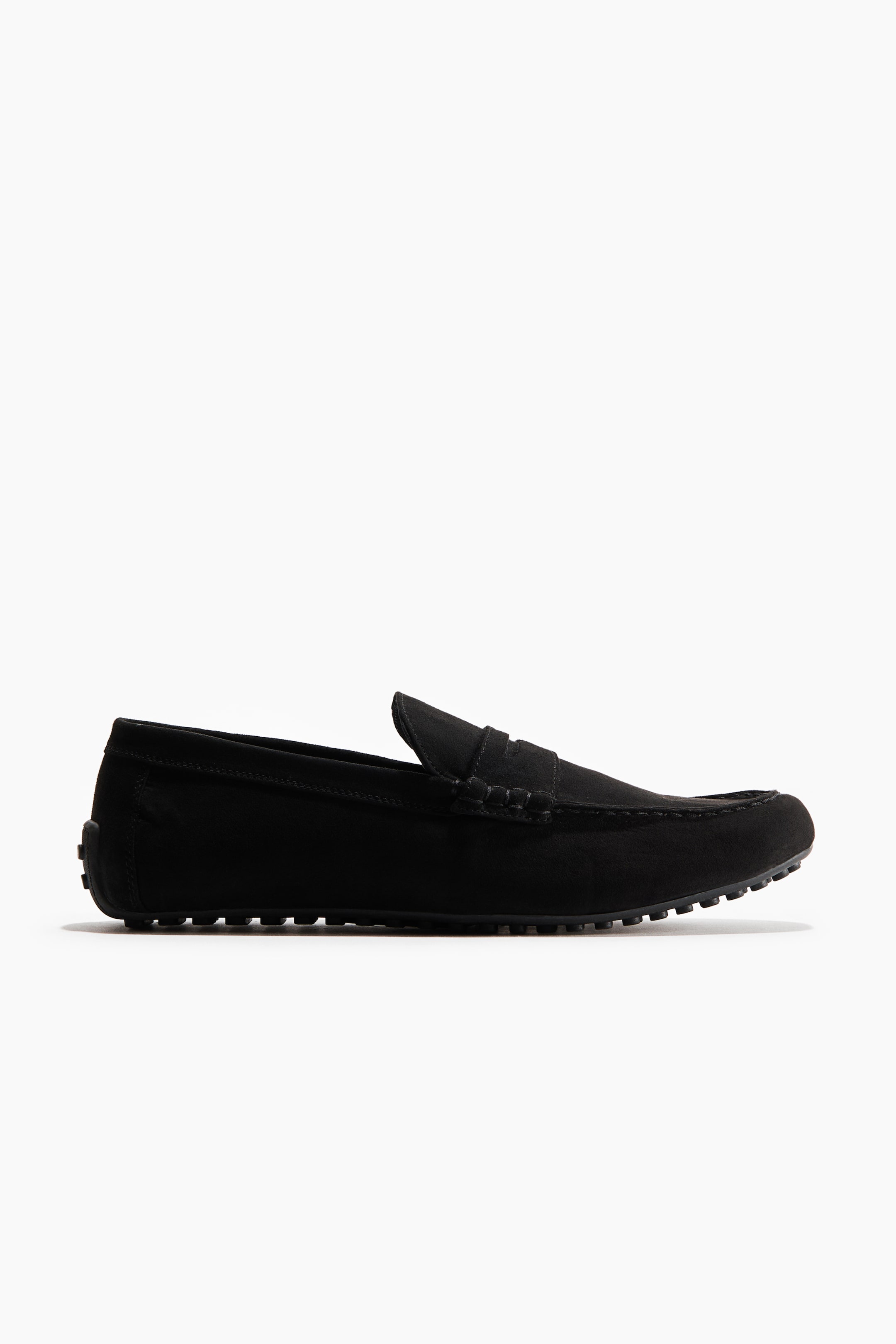 View larger image: A black suede driving loafer is facing right, featuring moccasin stitching on the toe, a penny strap across the vamp, and a pebbled rubber sole extending up the heel.