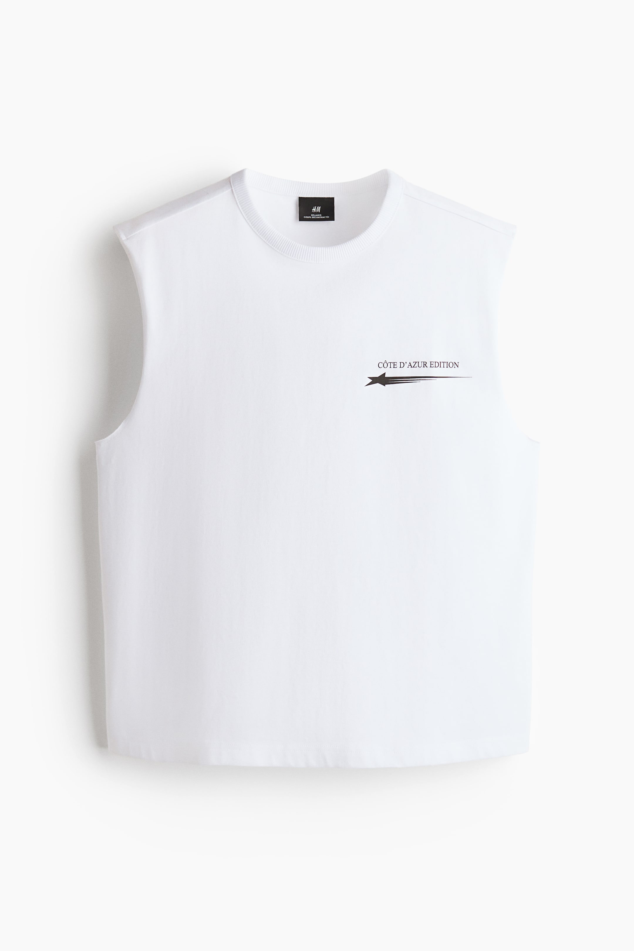 Xem ảnh lớn hơn: Áo vest cotton trắng được trưng bày mặt trước, với cổ tròn viền gân. Mặt trước được trang trí với họa tiết in 'CÔTE D'AZUR EDITION', bao gồm một ngôi sao và các đường kẻ, và áo được cắt với vạt thẳng, mang lại sự thoải mái với dáng rộng.
