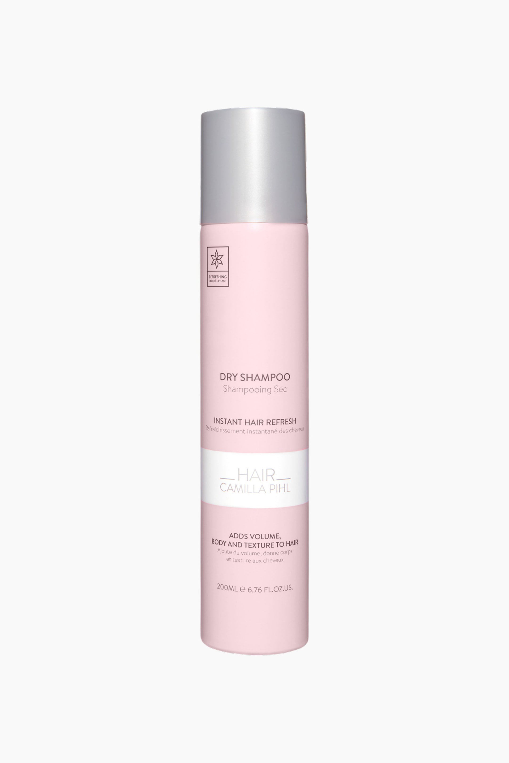 Vis større bilde: En rosa, sylindrisk tørrsjampo-aerosolboks står oppreist, og viser frem etiketten sin. Den har en sølvfarget hette og en hvit, rektangulær etikett på forsiden som fremhever ordene "DRY SHAMPOO" og "HAIR CAMILLA PIHL" sammen med en stjerneformet logo.
