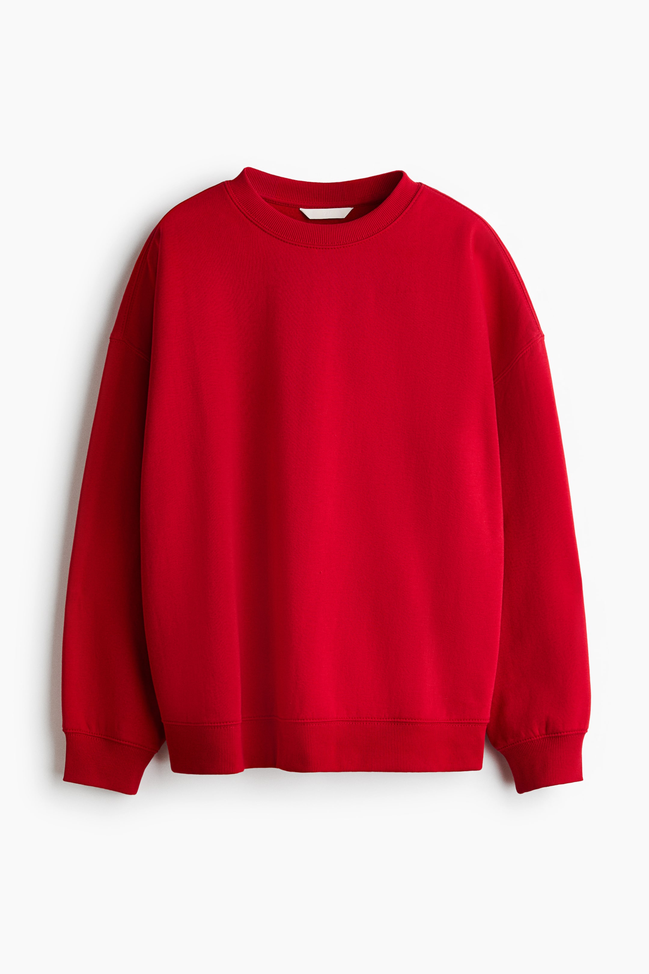 View larger image: A red oversized sweatshirt is shown from the front, featuring a crew neckline, dropped shoulders, and long sleeves. The garment includes ribbed detailing at the neckline, cuffs, and hem.