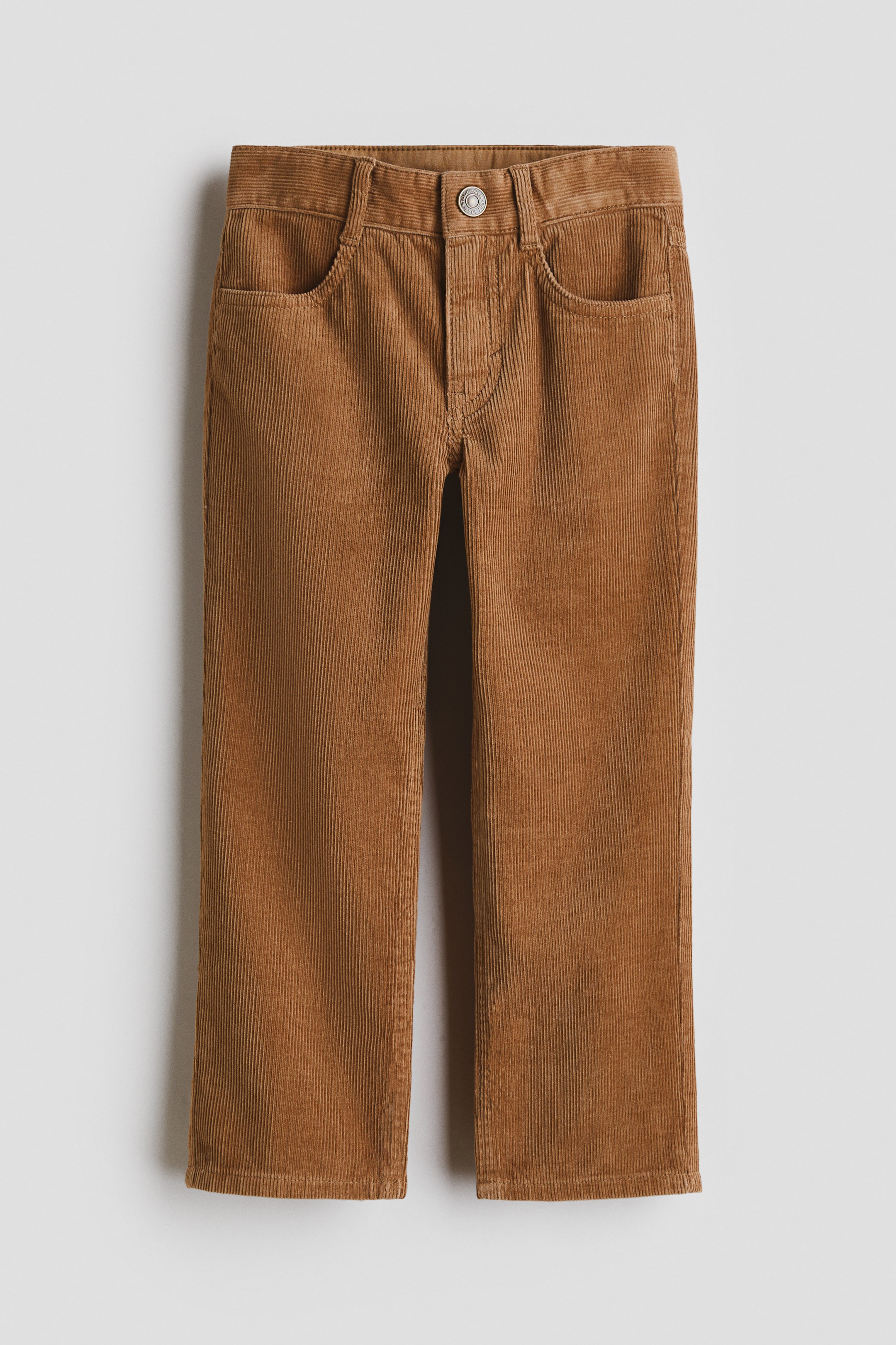 View larger image: Brown cotton corduroy trousers are shown in a front view, featuring a relaxed fit through the hip, thigh, and leg, a waistband with belt loops, a button closure at the fly, and two curved front pockets.