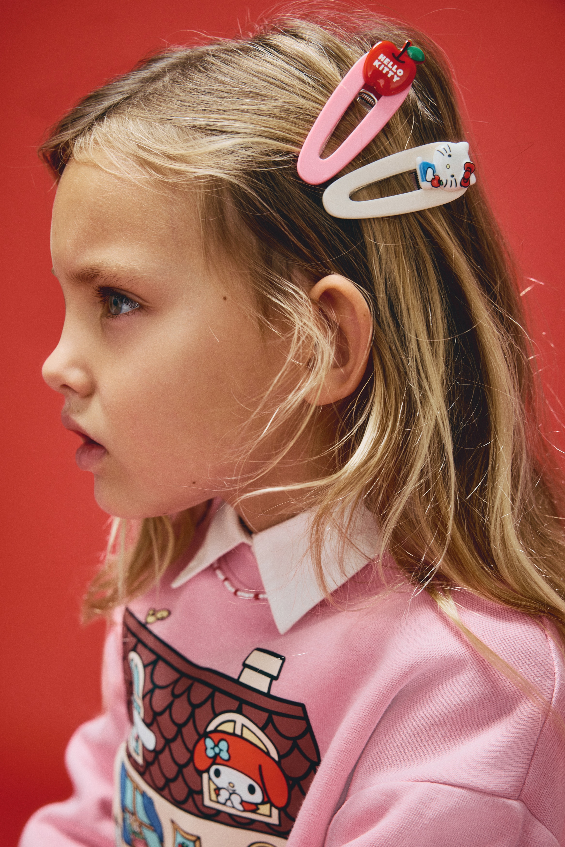 Neljän metallisen klipsin sarja esittelee erilaisia Hello Kitty -teemaisia kuvioita, katsottuna edestä. Kaksi klipsiä esittää valkoisia Hello Kitty -päitä, joista toisella on punainen rusetti ja toinen pitelee omenaa ja maitotölkkiä. Kolmas klipsi näyttää ruskean nallen pään punaisella rusetilla, ja neljäs esittää punaista omenaa "Hello Kitty" -tekstillä.