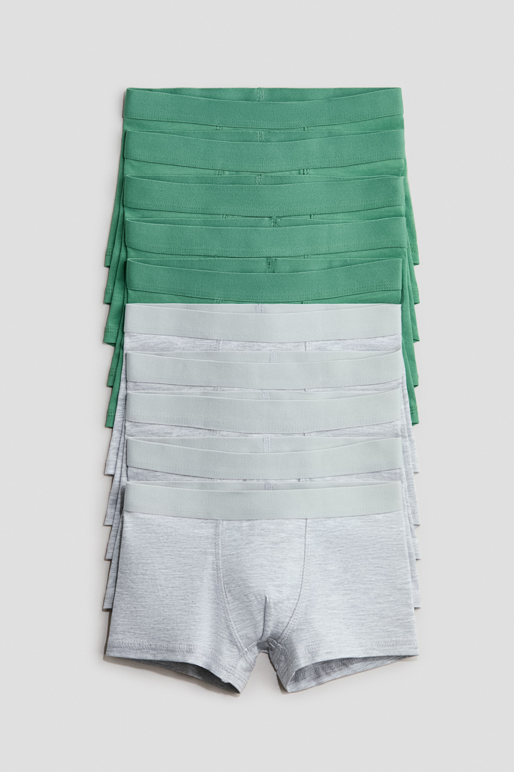 Größeres Bild ansehen: Ein Stapel von zehn Baumwolljersey-Shorts wird präsentiert, wobei die oberen fünf Paare grün und die unteren fünf heather grey sind. Jede Shorts verfügt über kurze Beine, einen elastischen Bund und eine konturierte Fronttasche.