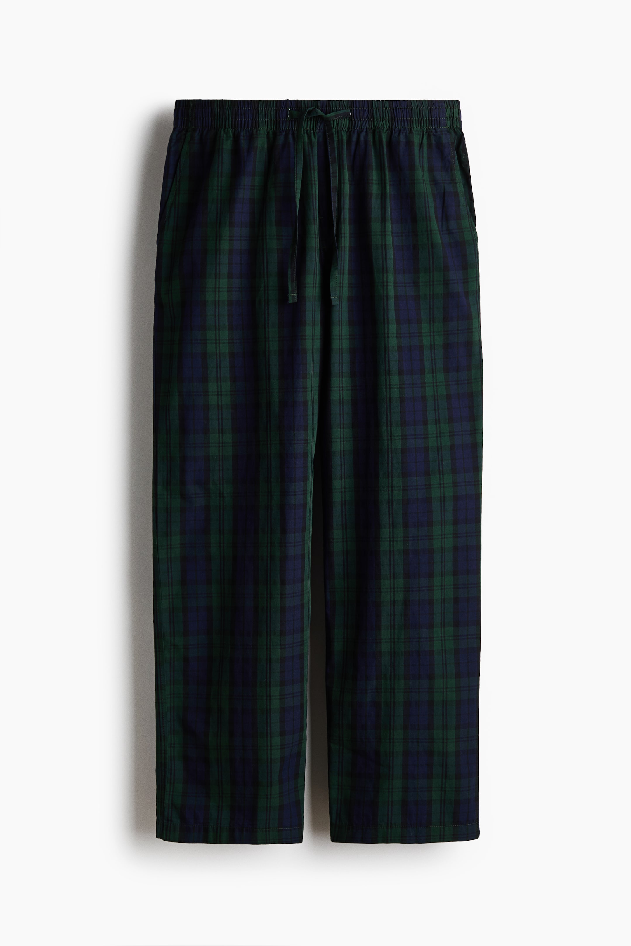Ver imagen más grande: Los pantalones de cuadros presentan un estampado tartán en verde y azul marino, vistos de frente. Cuentan con una cintura elástica con cordón central y dos bolsillos laterales, además de perneras rectas rematadas con un bajo sencillo.