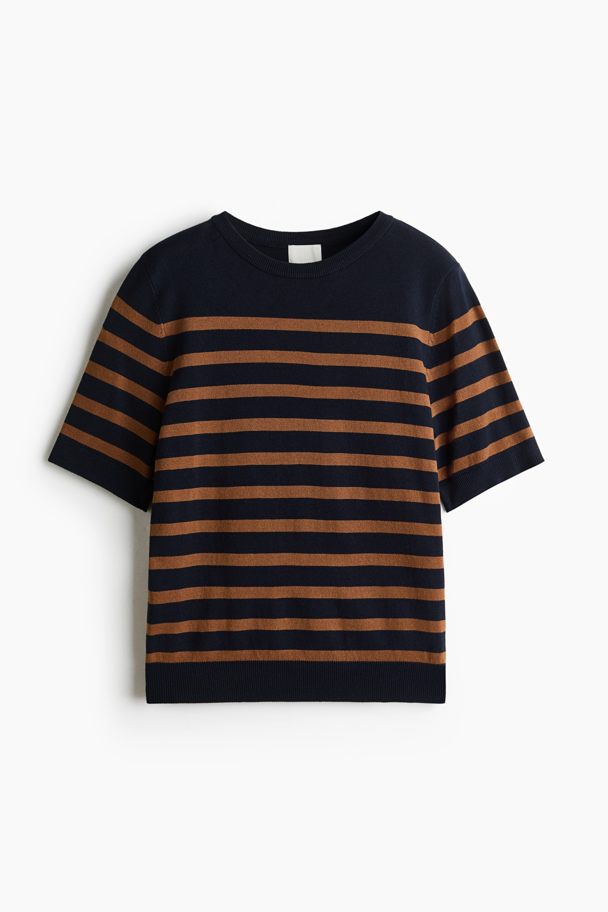A fine-knit, striped sweater featuring a round, rib-trimmed neckline and short sleeves is being worn by the model. The black and brown striped sweater is tucked into a pair of wide-leg, dark-wash jeans.
