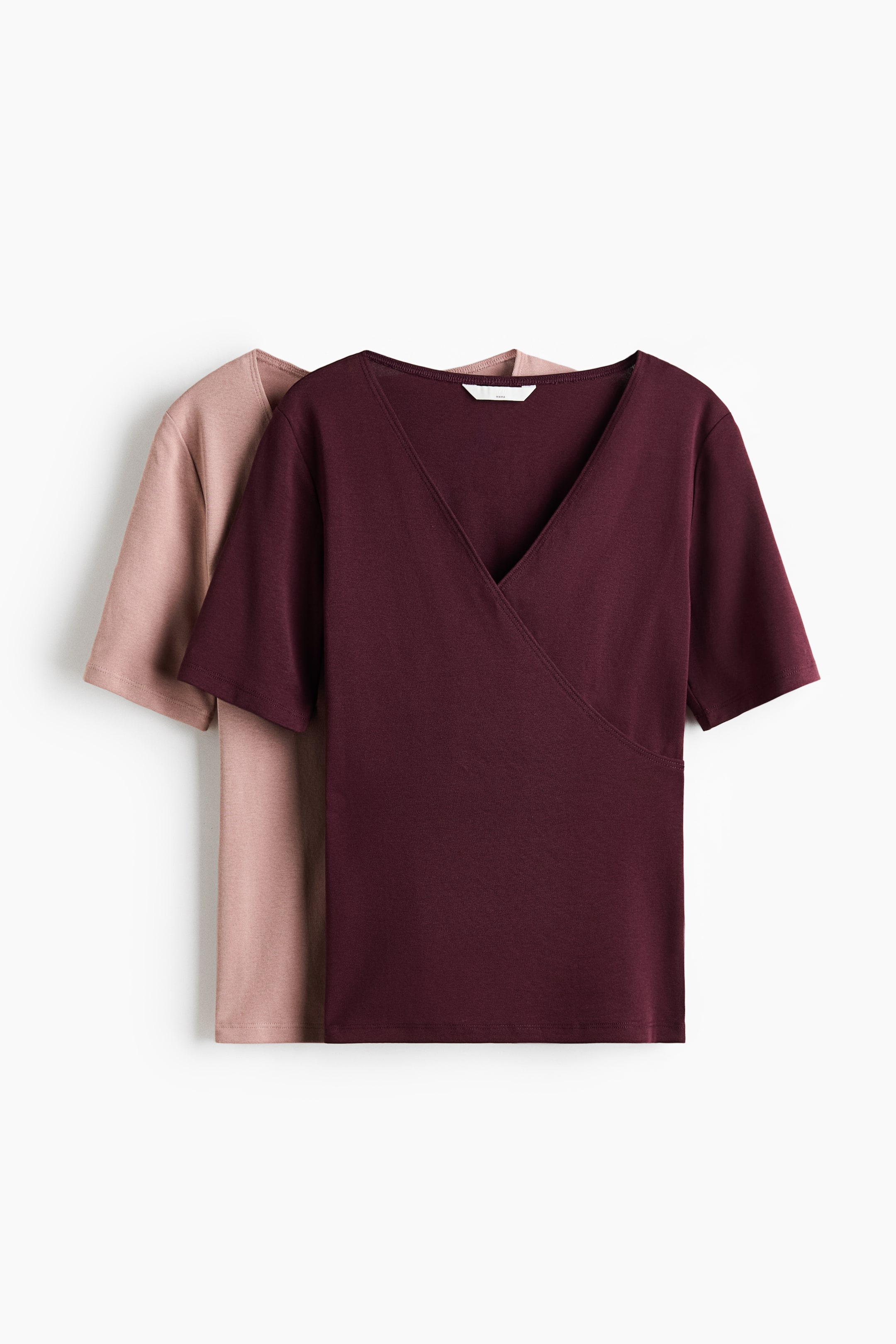 Agrandir l'image: Deux hauts d'allaitement ajustés en jersey de coton doux sont présentés de face, avec un haut bordeaux superposé à un haut rose clair. Les deux hauts présentent un décolleté en V, des manches courtes et une section superposée à l'avant.