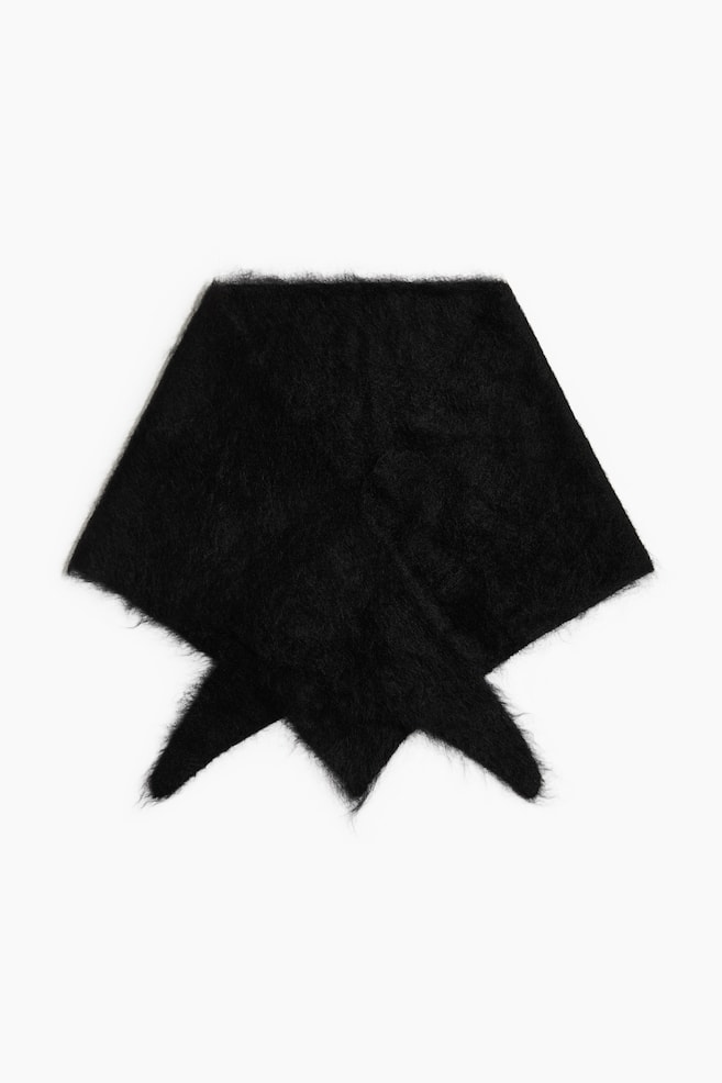 Ein schwarzer, flauschiger Strickschal liegt flach in einer Frontansicht, zu einer dreieckigen Form gefaltet, wobei sich die spitzen Enden unten Ã¼berlappen. Der Schal hat eine strukturierte, haarige OberflÃ¤che mit weichen, gebÃ¼rsteten Fasern. - 1