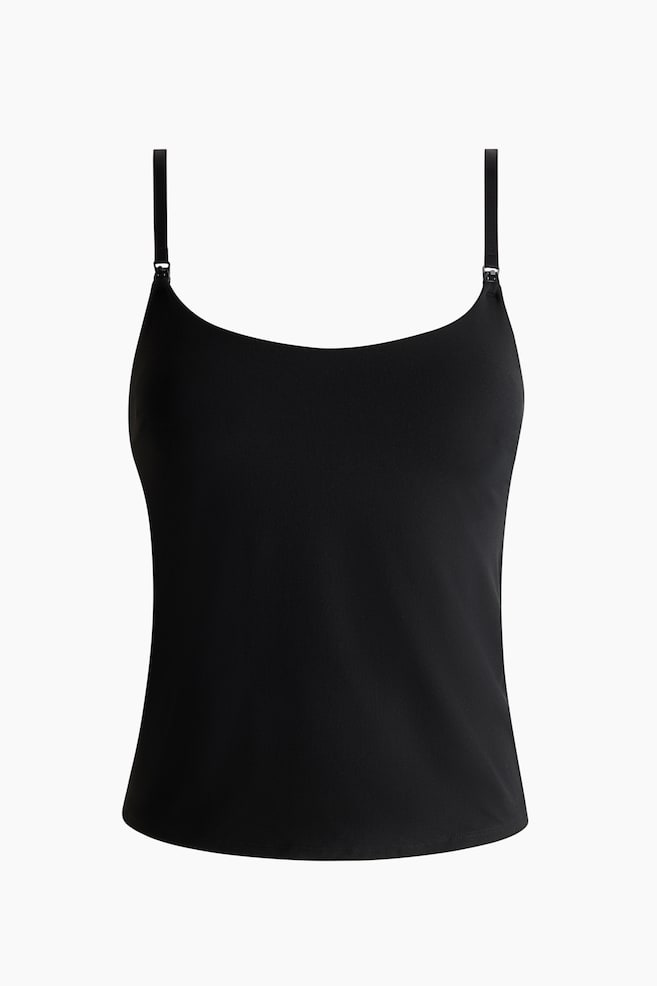 Een zwarte camisole wordt van de VOORKANT gepresenteerd, met een ronde halslijn en dunne, verstelbare schouderbandjes. Een kleine metalen versteller is zichtbaar aan de voorkant van de linkerband, en de camisole heeft een gladde textuur en een rechte zoom. - 1
