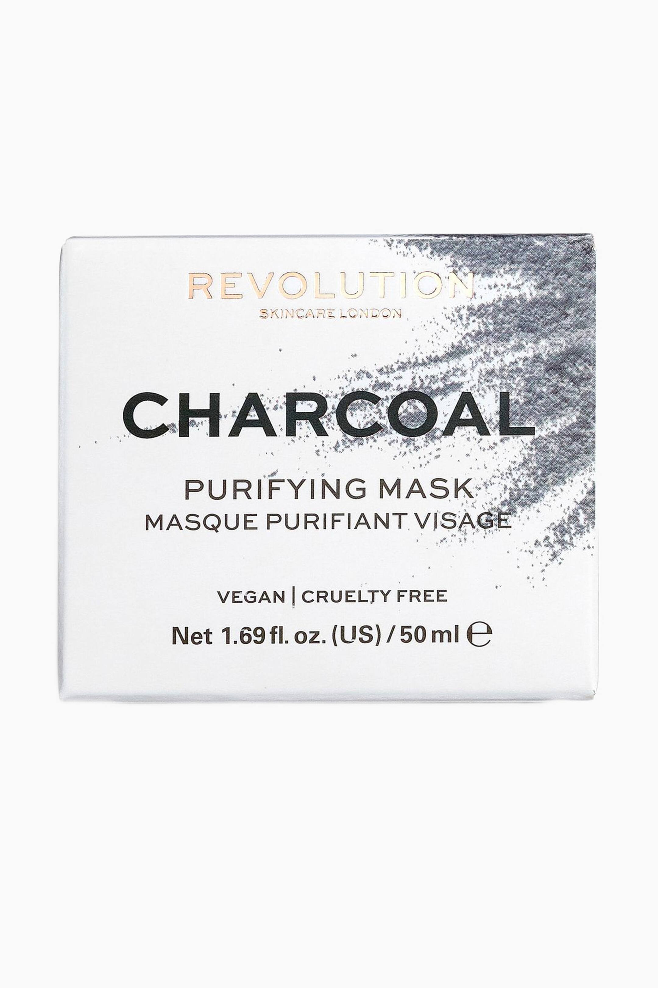 Größeres Bild ansehen: Eine rechteckige weiße Schachtel für die Revolution Skincare Charcoal Purifying Mask ist nach vorne ausgerichtet und zeigt oben rechts eine strukturierte grafische Darstellung von grauem Holzkohlepulver. Die Vorderseite präsentiert oben ein Branding in metallischem Roségold, in der Mitte eine fett gedruckte schwarze Produktbezeichnung und unten Produktdetails.