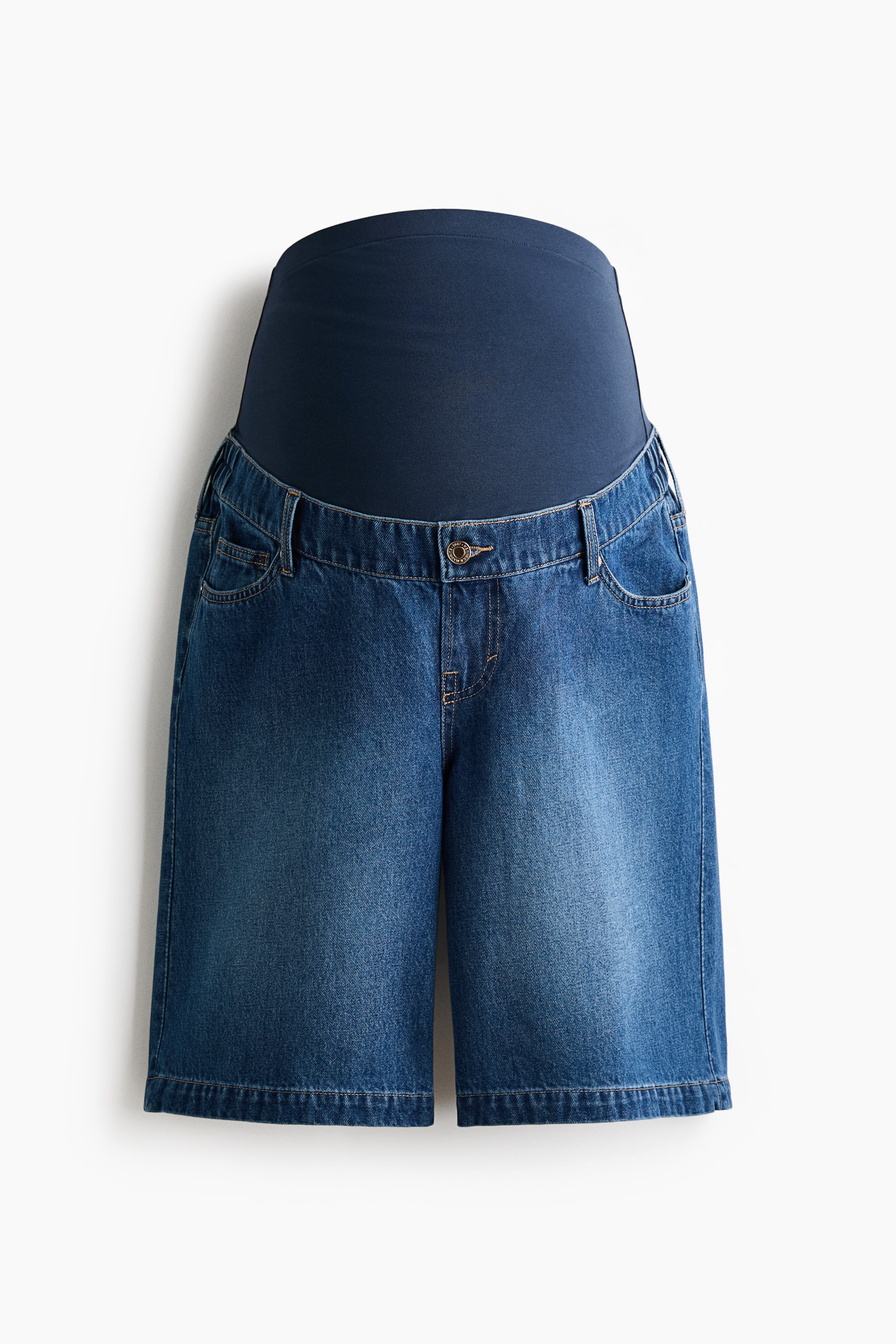 View larger image: Knee-length blue cotton denim Bermuda shorts are shown from the front, showcasing a 5-pocket design and a button closure. A wide navy jersey panel forms the waistband for a comfortable fit over the tummy, with covered elastic visible at the denim's sides.