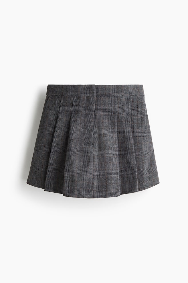 A gray Prince of Wales check mini skirt is being presented from the front, featuring a flat waistband and multiple box pleats that form a flared silhouette. - 1