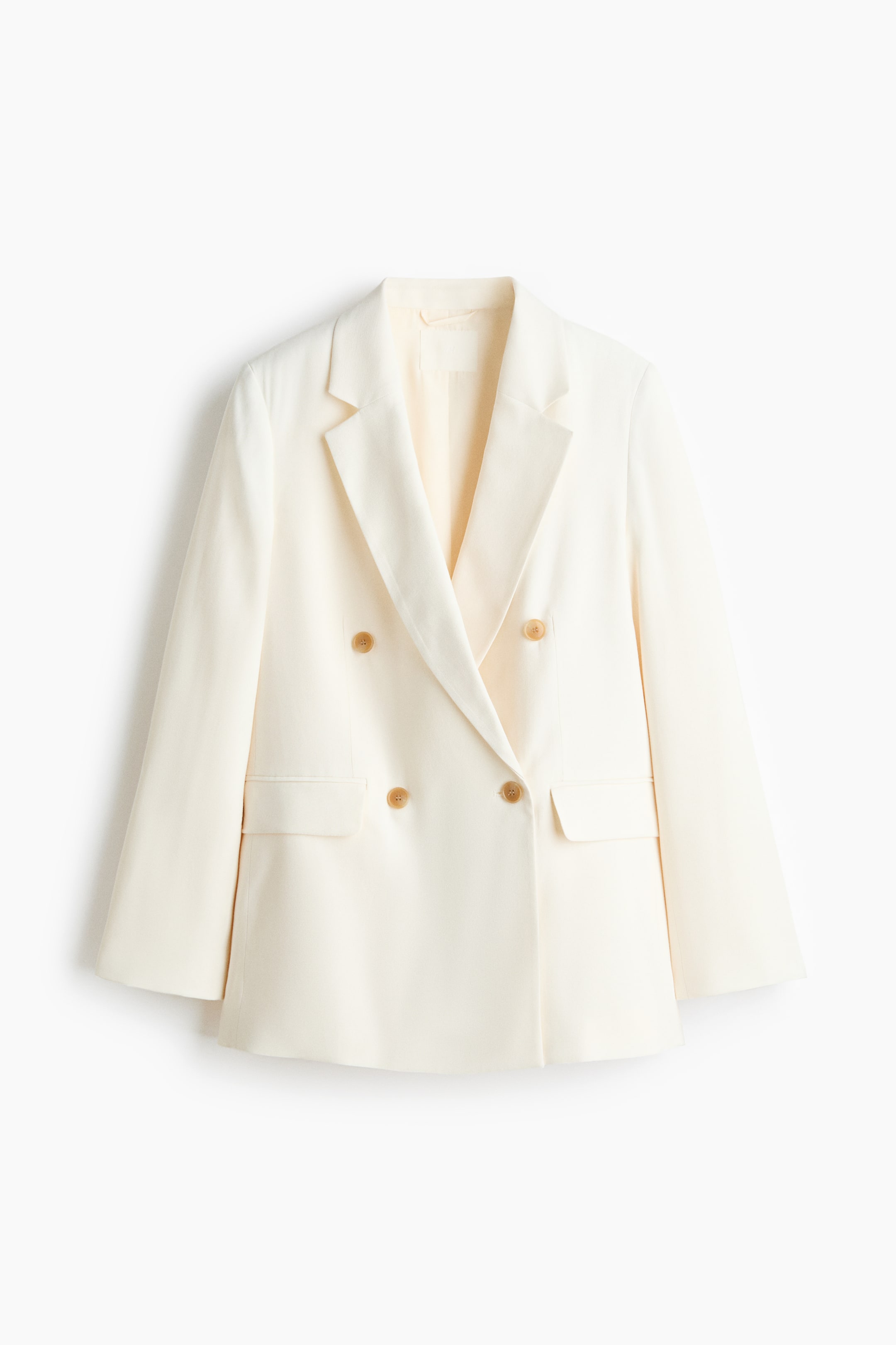 Ver imagen más grande: Una americana cruzada de color crema presenta su parte frontal, con un largo ligeramente mayor, solapas de muesca, cuatro botones marrón claro, mangas largas y dos bolsillos delanteros con solapa.