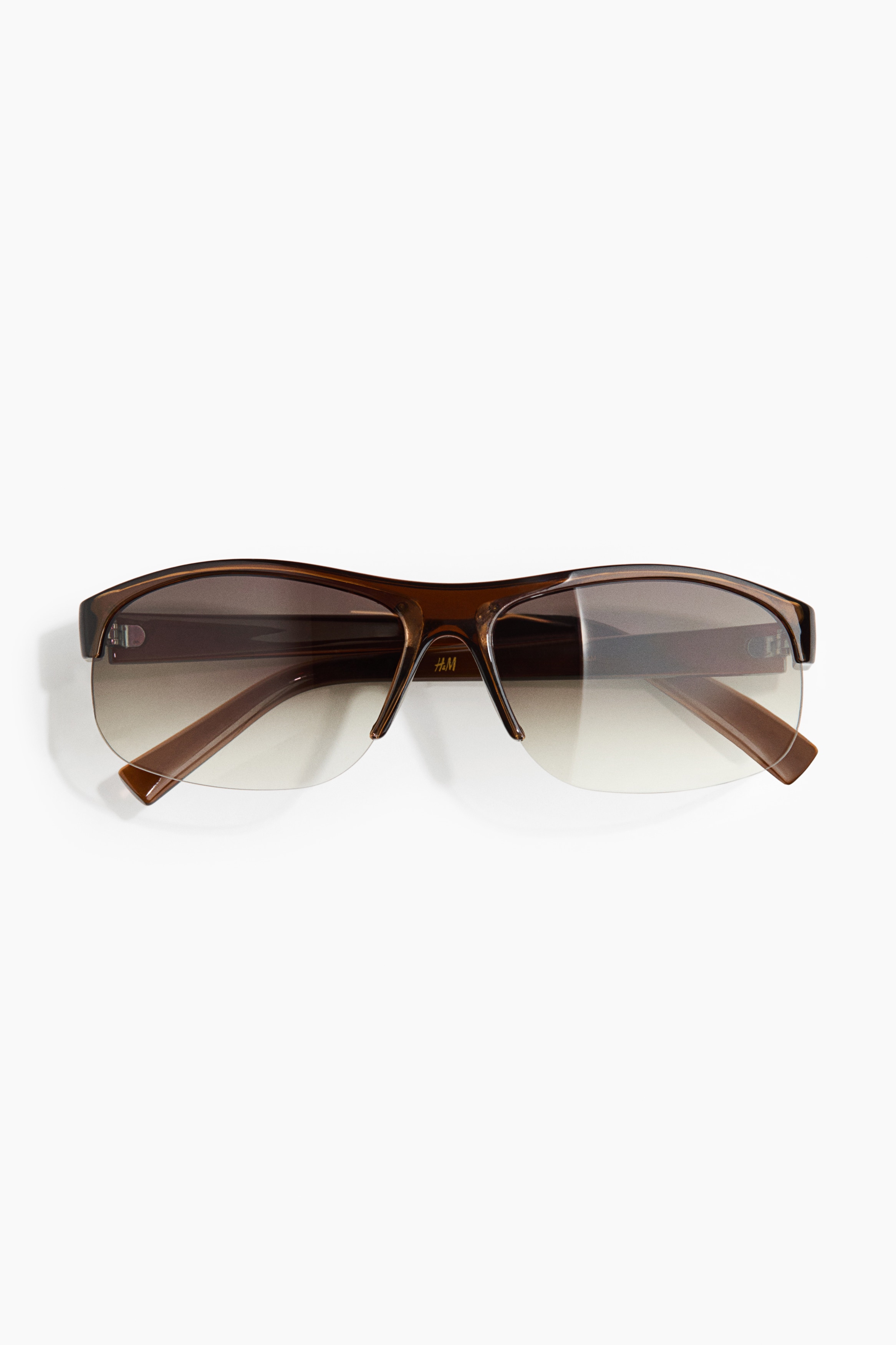 Sporty sunglasses featuring a brown plastic half-frame with plastic sidepieces and tinted, UV-protective plastic lenses, presented with the sidepieces folded inward.