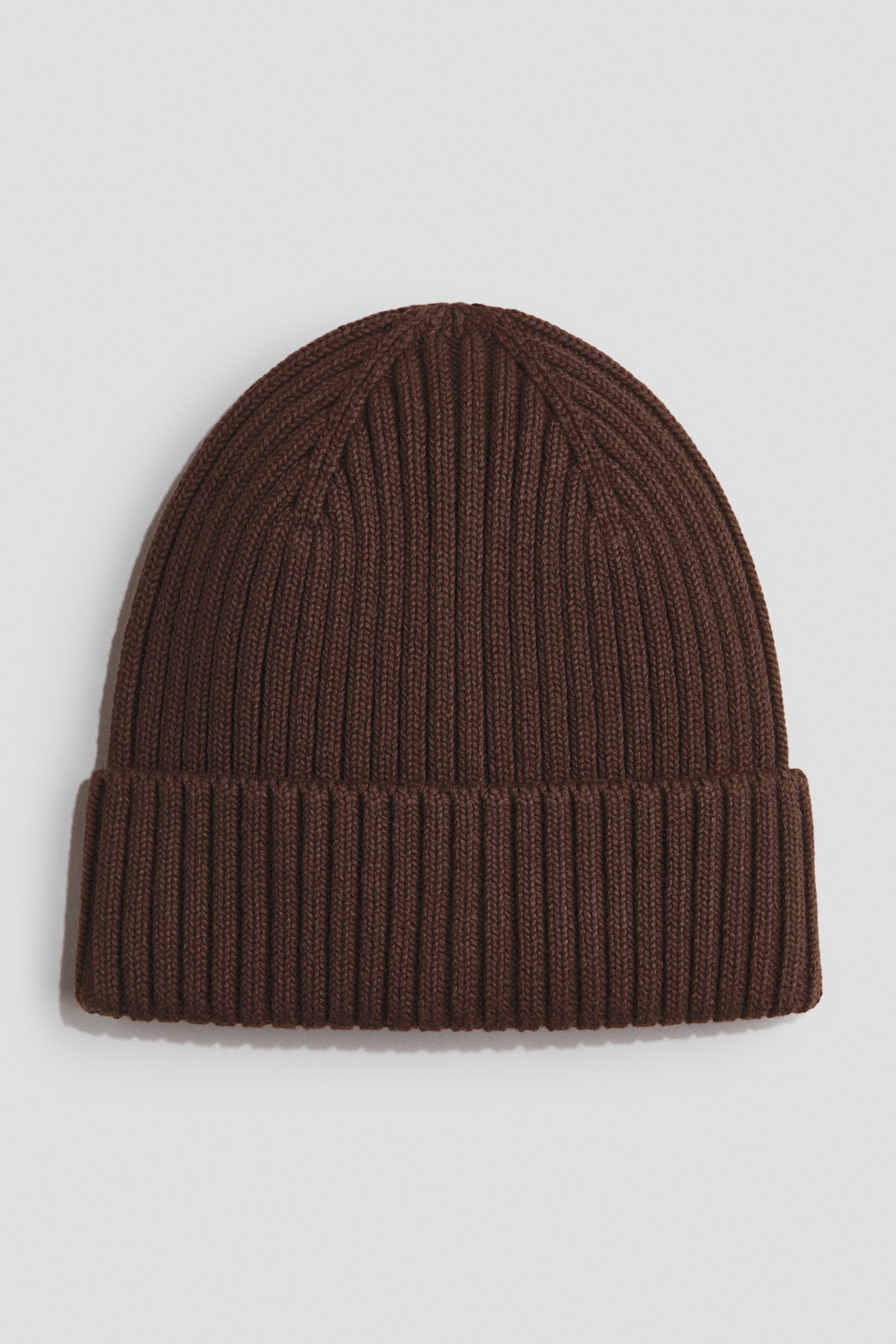 View larger image: A brown beanie featuring a rib knit construction and showcasing a turn-up at the hem.