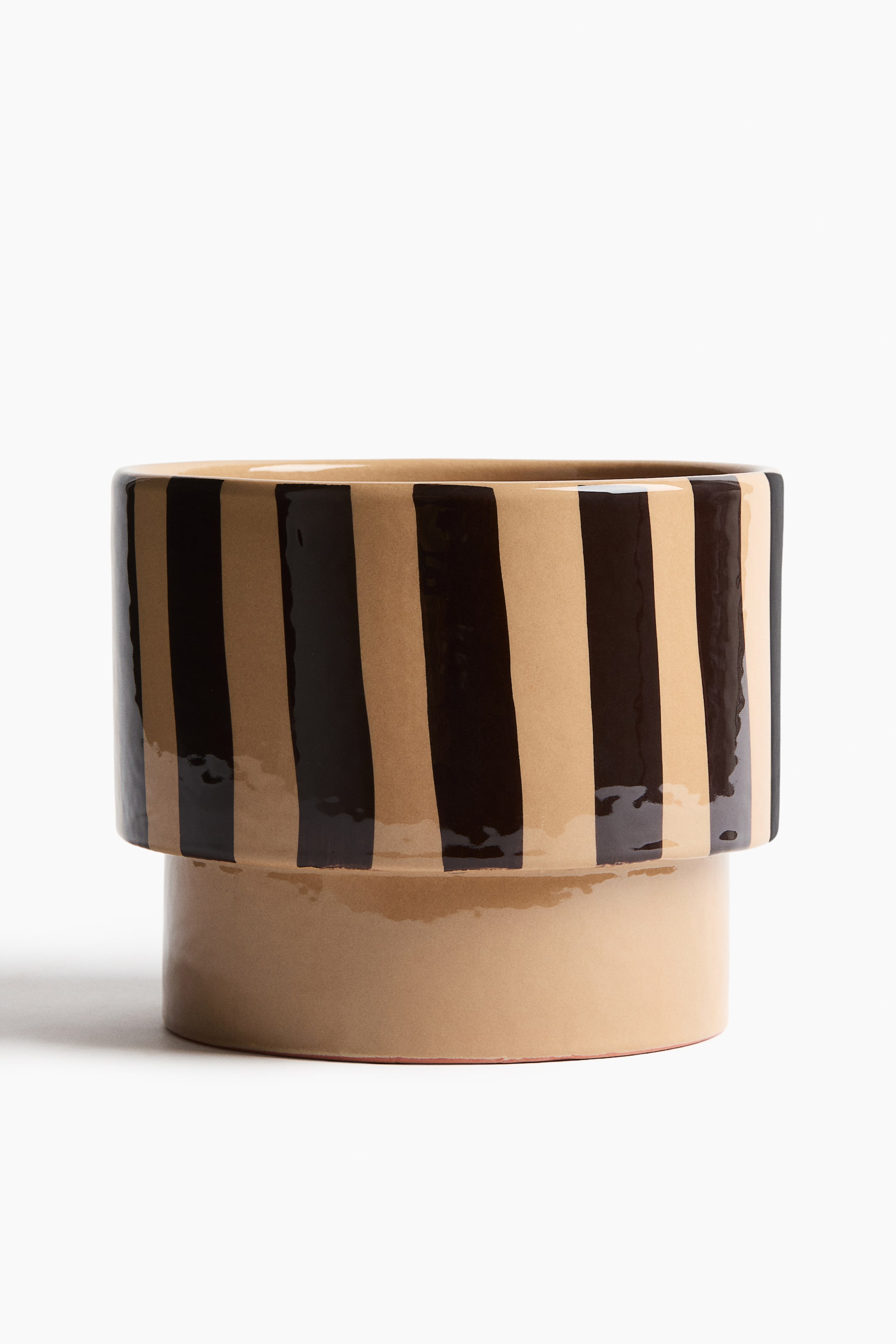 Agrandir l'image: Un pot de plante est présenté de face, mettant en valeur un émail réactif sur terracotta. Il présente un design avec des rayures verticales marron clair et marron foncé sur sa partie supérieure plus large, tandis que sa partie inférieure plus étroite est d'un marron clair uni.