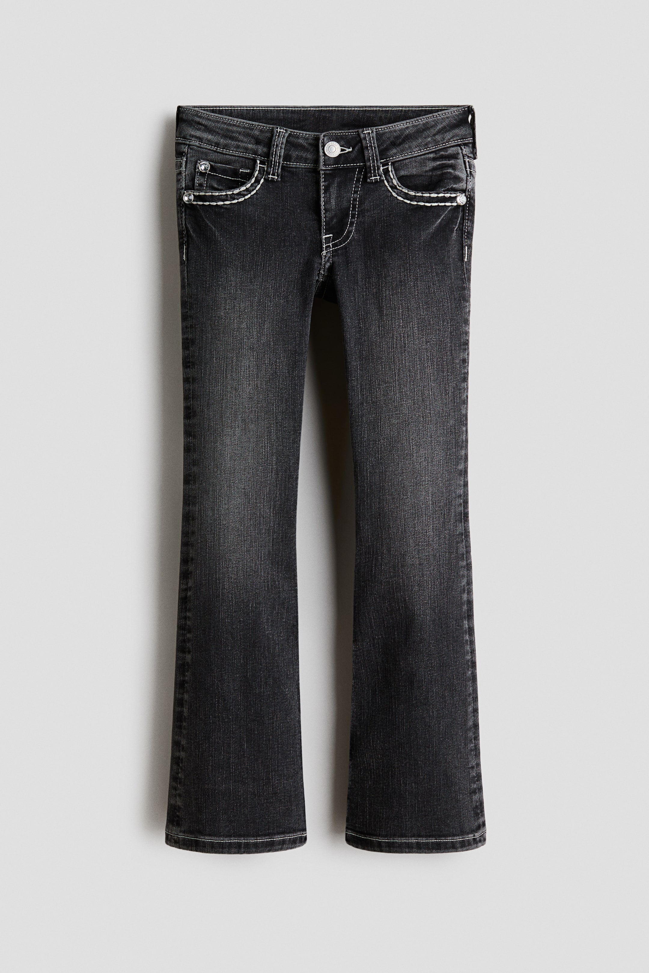 View larger image: Dark grey washed denim jeans showcase a bootcut fit, appearing skinny from the waist to the thigh and flaring from the knee to the hem. They feature worn-out details, a low waist, a front zip fly with a button, front pockets, a coin pocket, and white contrast stitching.