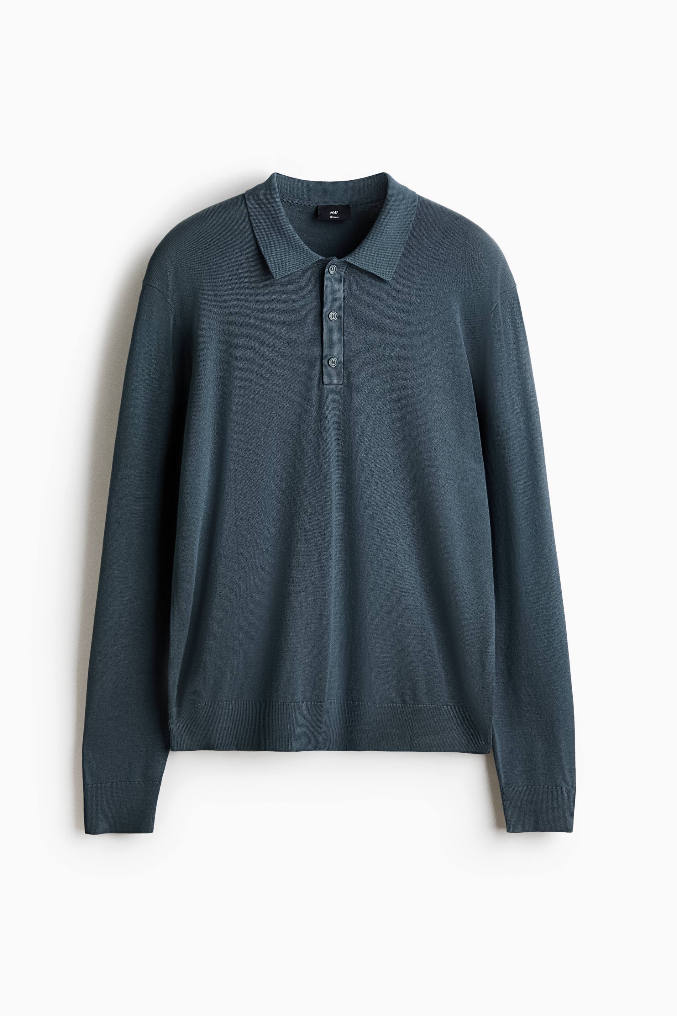 View larger image: A long-sleeved polo shirt is shown from the front in a dark teal colour, featuring a fine knit construction. It is designed with a collar and a three-button placket, while ribbed cuffs and a ribbed hem complete the regular-fit silhouette.