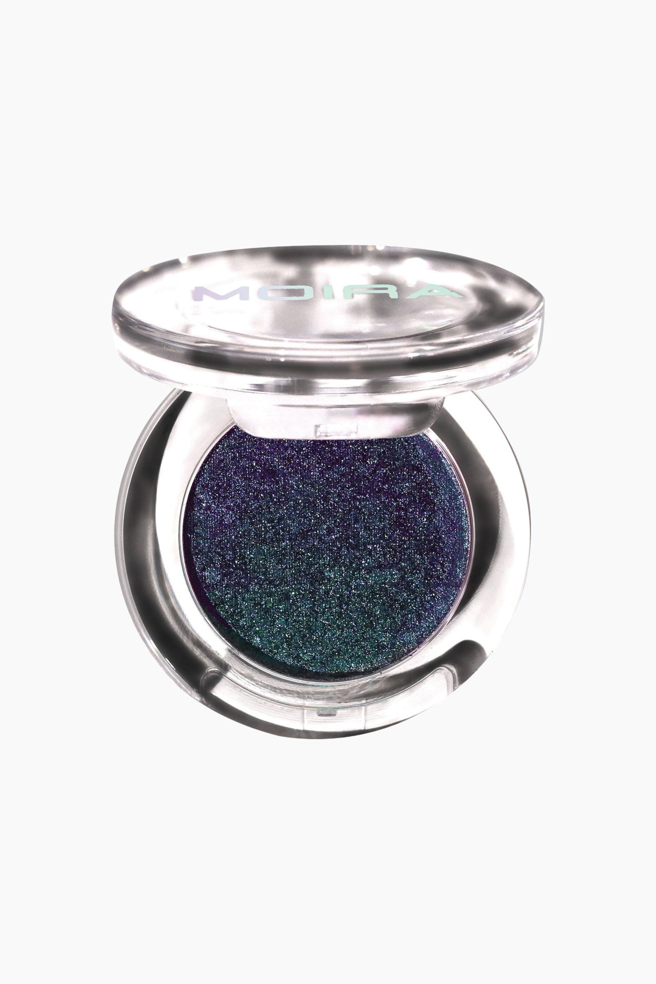 Visa större bild: Supernova Glitz Shadow ligger i en öppen, rund transparent plastkompakt och visar upp en kupolformad skimrande ögonskugga. Ögonskuggan har en duokrom effekt med en övergång som skiftar från djupt lila till glittrande tealgrönt.