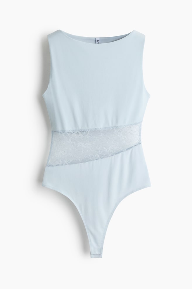Um body azul claro sem mangas está disposto plano, apresentando um decote barco e um painel largo de renda azul claro translúcida na diagonal pela seção média, terminando numa parte inferior estilo tanga. - 1