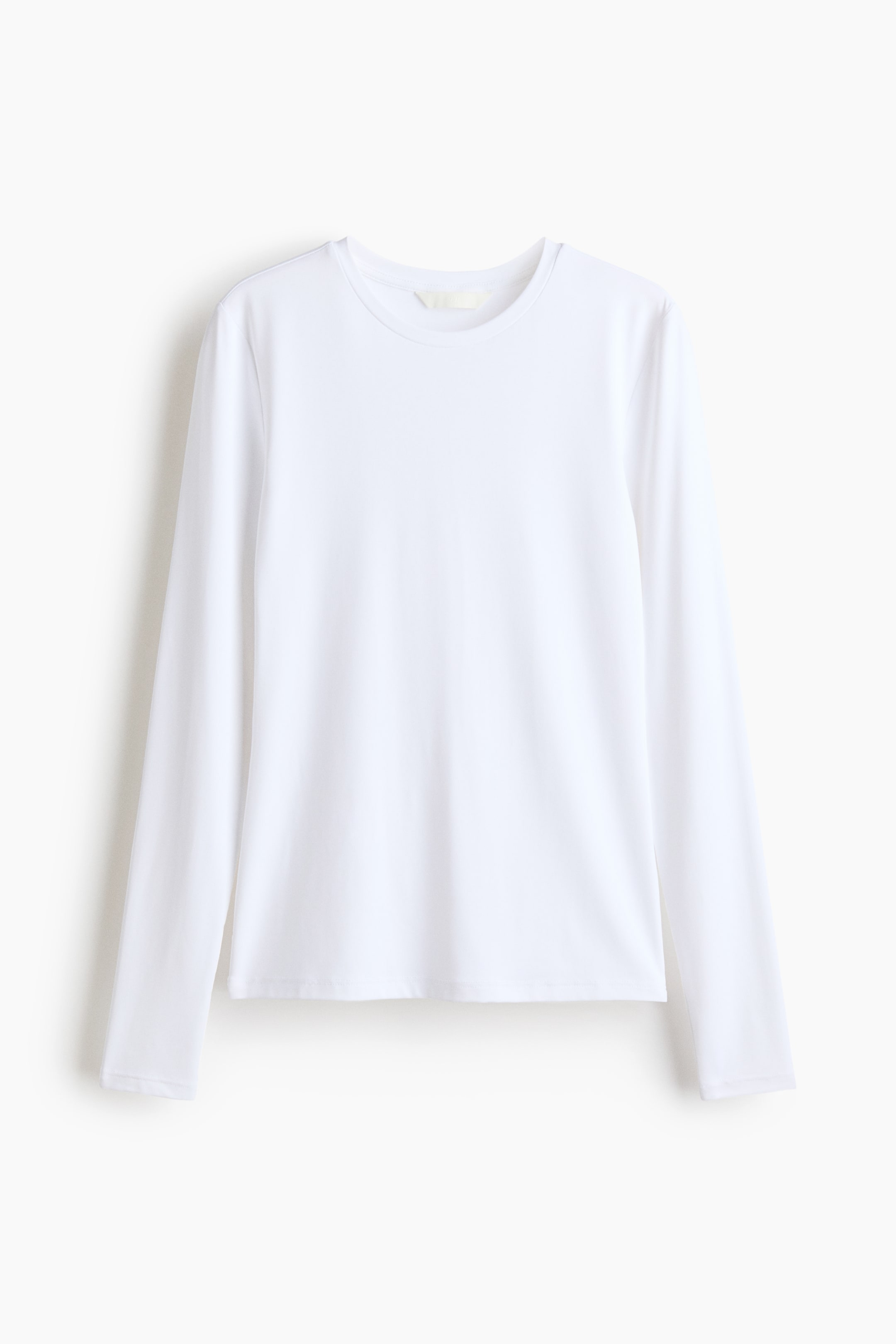 Größeres Bild ansehen: Ein weißes Langarmshirt wird von vorne präsentiert, mit Rundhalsausschnitt und langen Ärmeln. Es zeigt eine glatte Textur und einen geraden Saum, mit einem hellen Etikett, das am hinteren Halsausschnitt sichtbar ist.