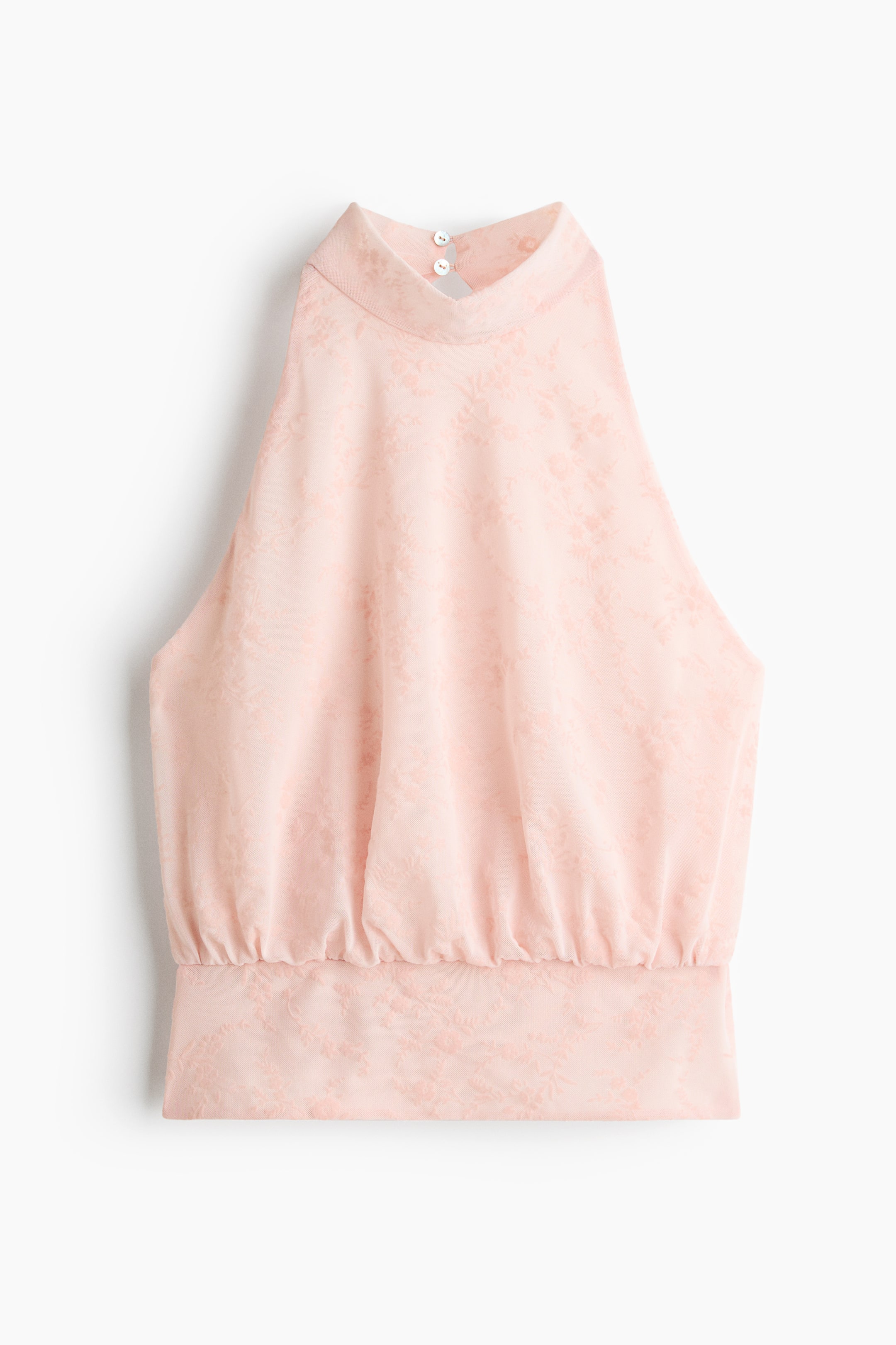 Größeres Bild ansehen: Ein hellrosa Jacquard-Mesh-Short-Top wird von vorne gezeigt und zeichnet sich durch ein dezentes Blumenmuster, einen schmalen Ausschnitt im oberen Bereich sowie einen Stehkragen aus, der in ein Halterneck-Trägerdetail übergeht und am Rücken mit zwei weißen Knopf-Schlingen-Verschlüssen geschlossen wird. Ein breiter Bund mit geraffter oberer Kante rundet das Design ab.